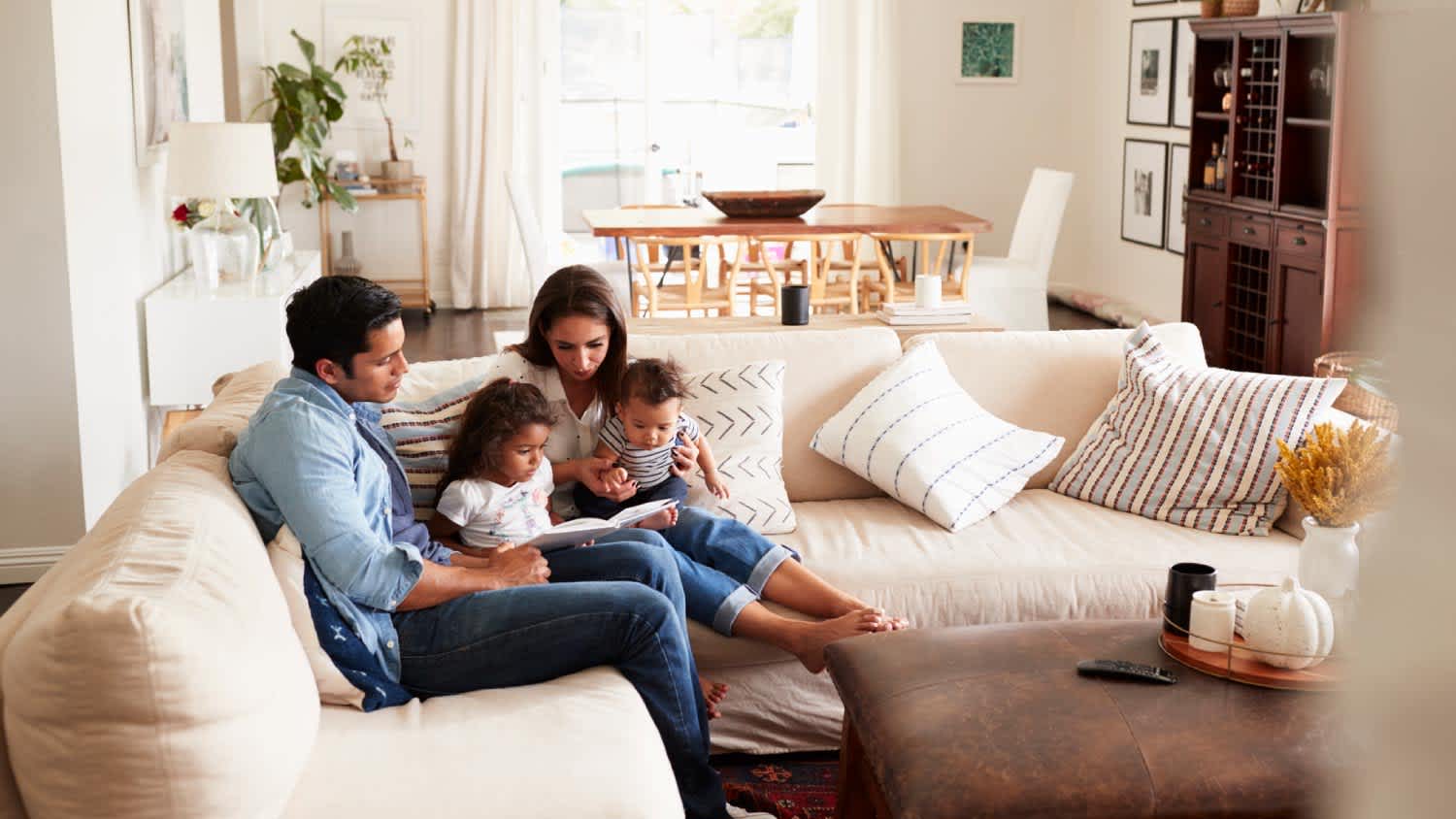Family sitting on sofa reading a book