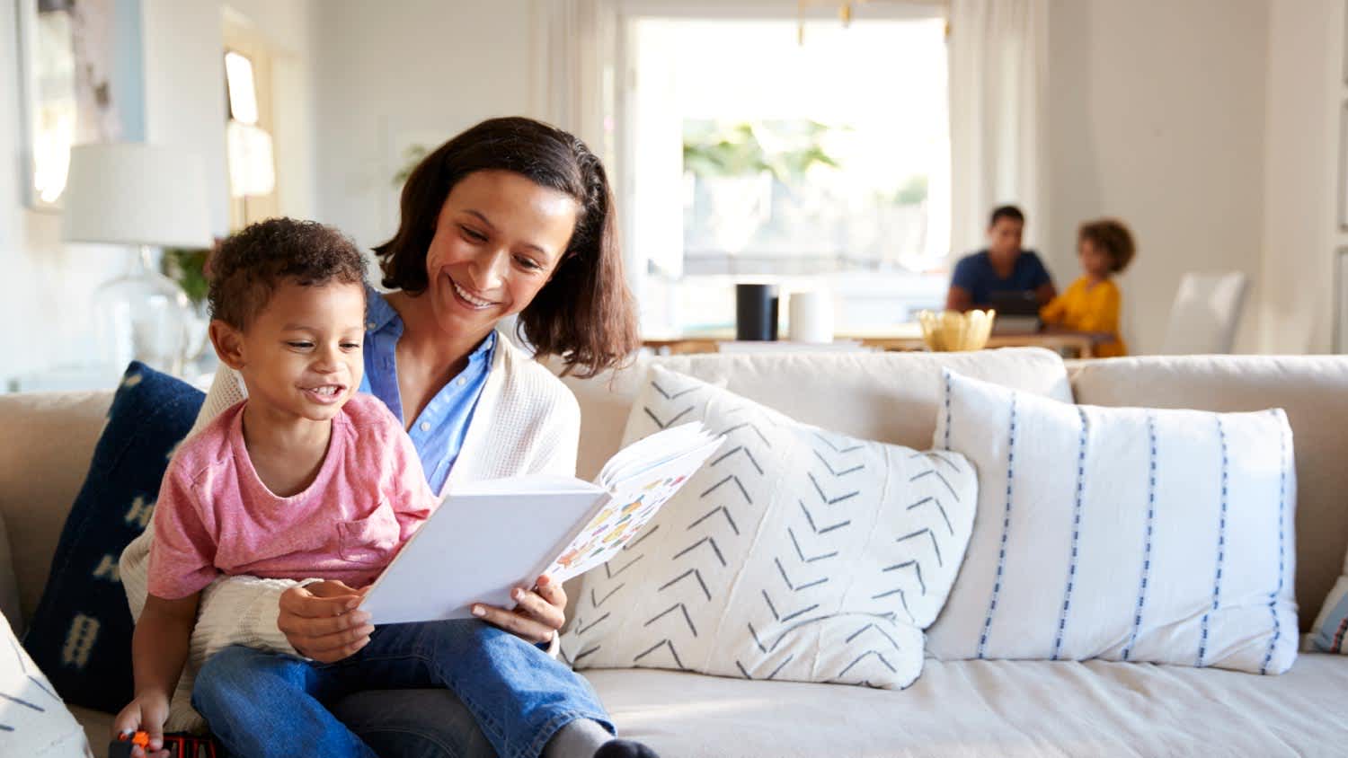 A mother sitting on sofa in the living room with her toddler