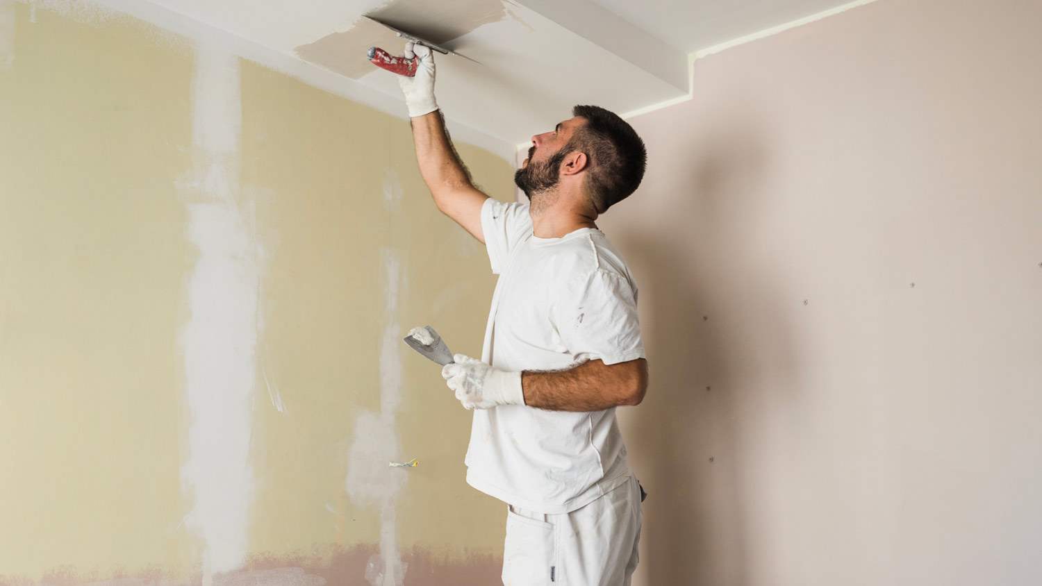 man putting veneer plaster on ceiling