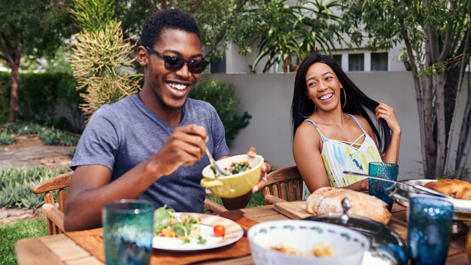 None friends laughing and eating outside