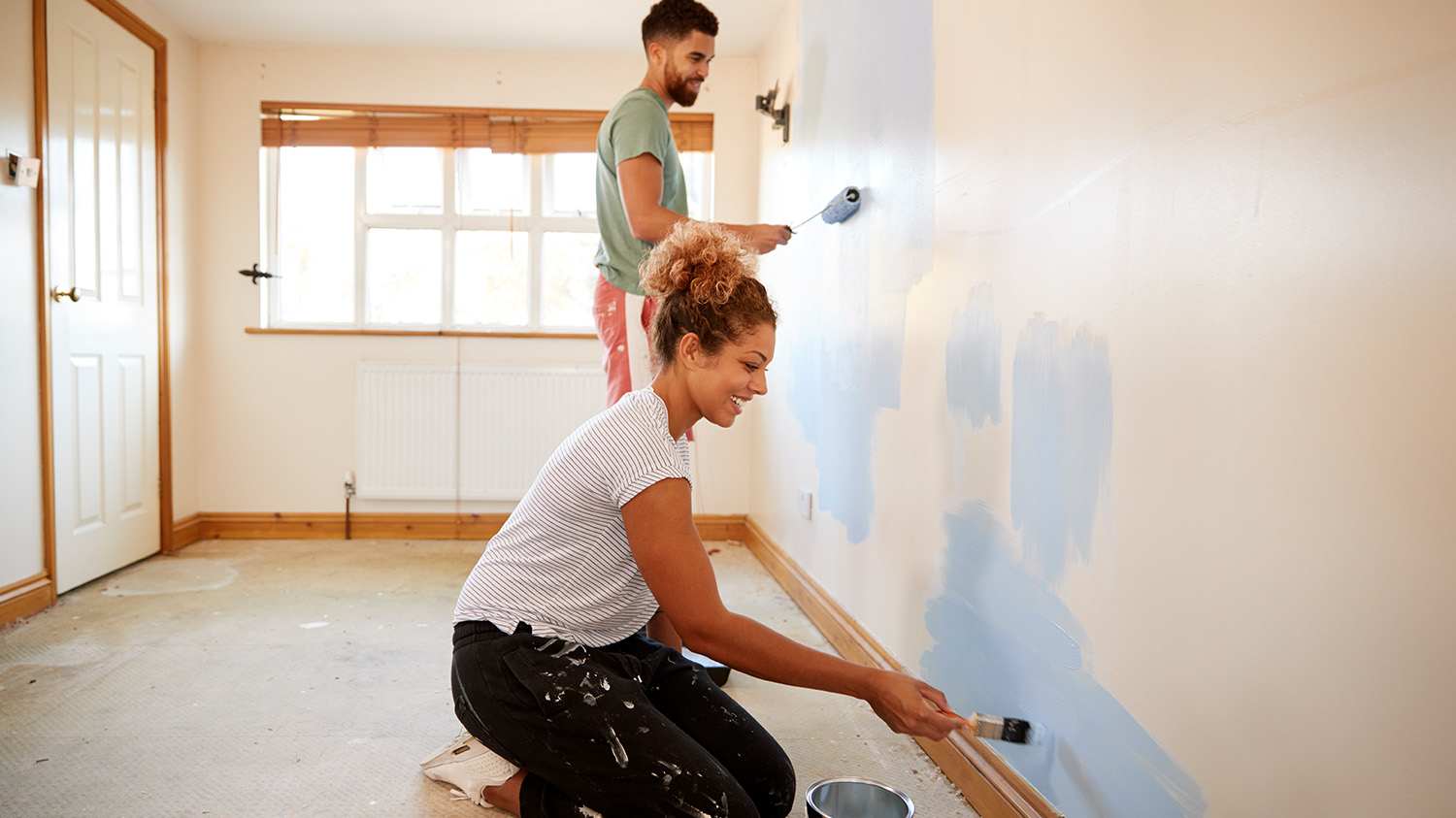 Couple together adding fresh paint to walls