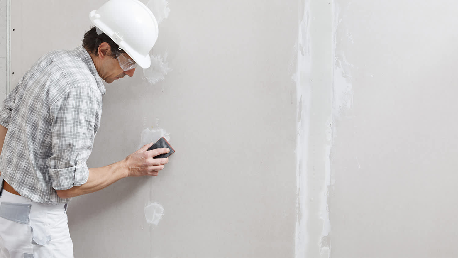 None Man sands patched drywall