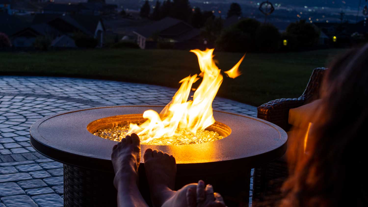 None woman sitting by outdoor fireplace