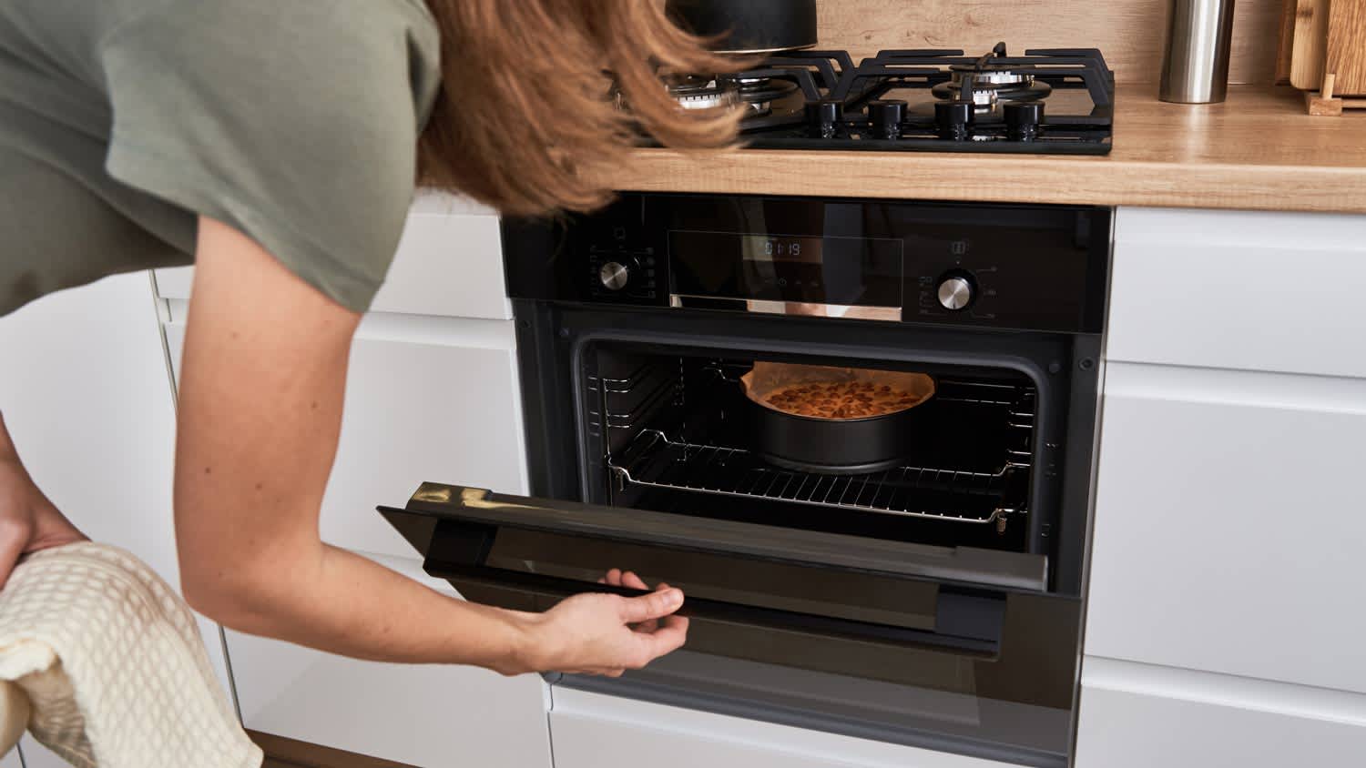 woman cooking cake in oven