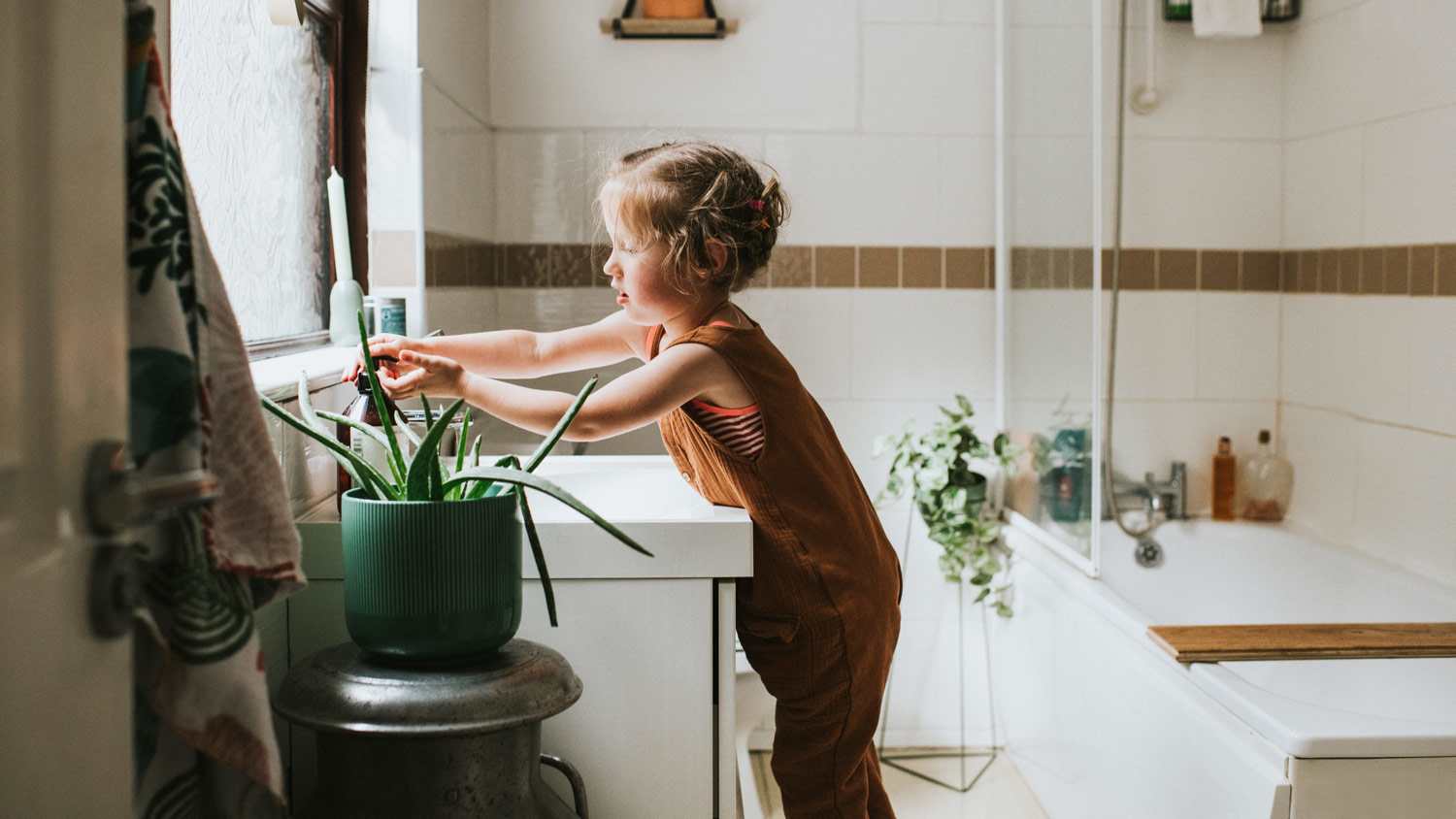 A little girl washing her hands in bathroom sink