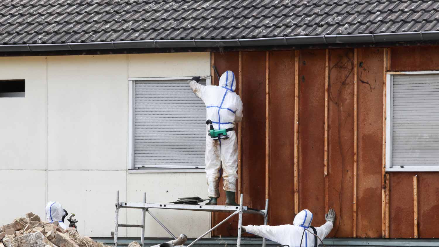 Workers in protective suits removing asbestos