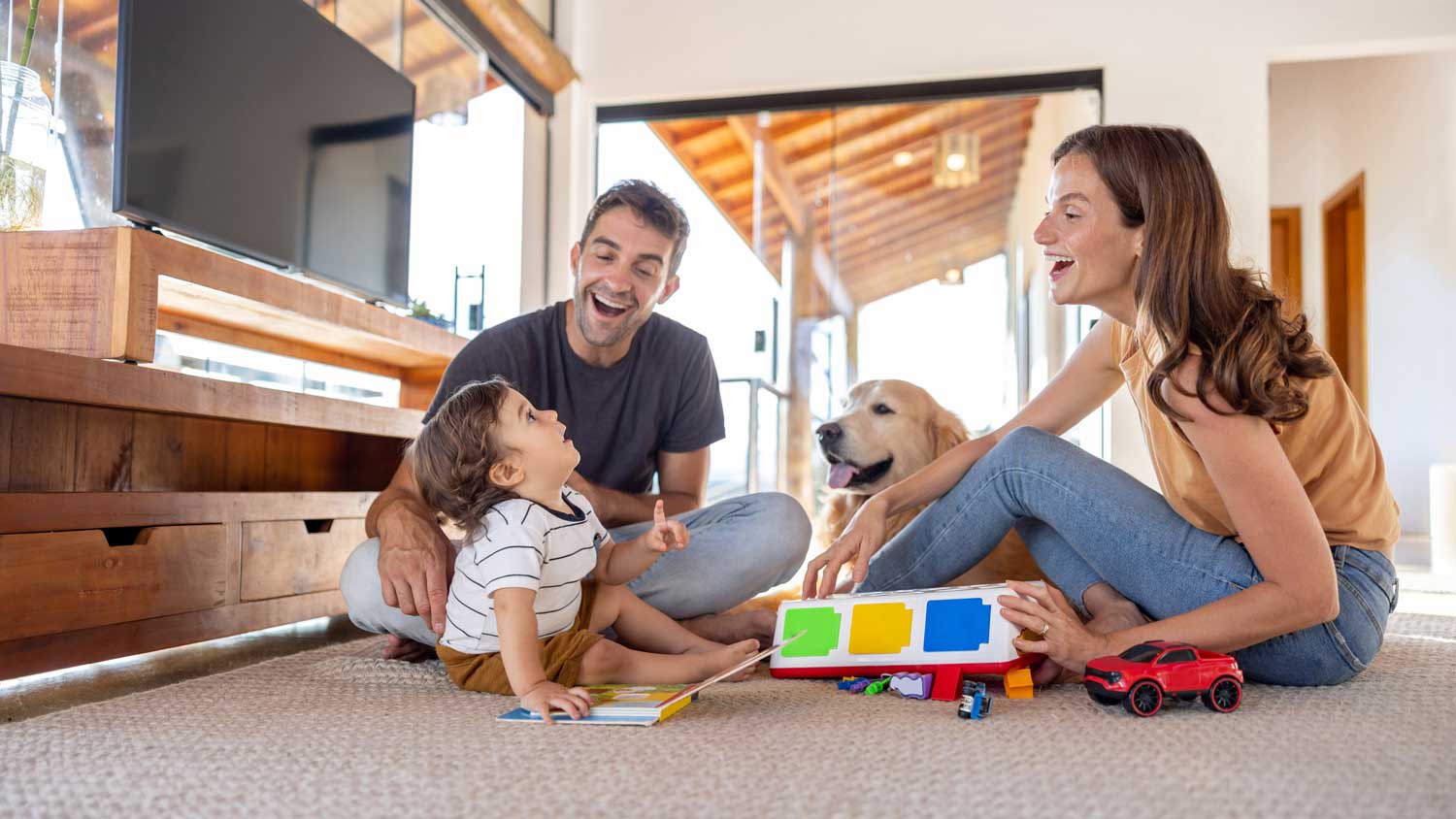 parents playing with baby and dog