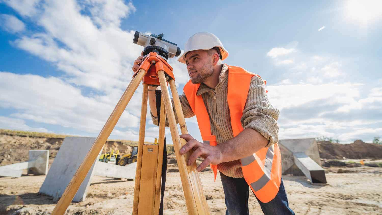 Worker with theodolite equipment