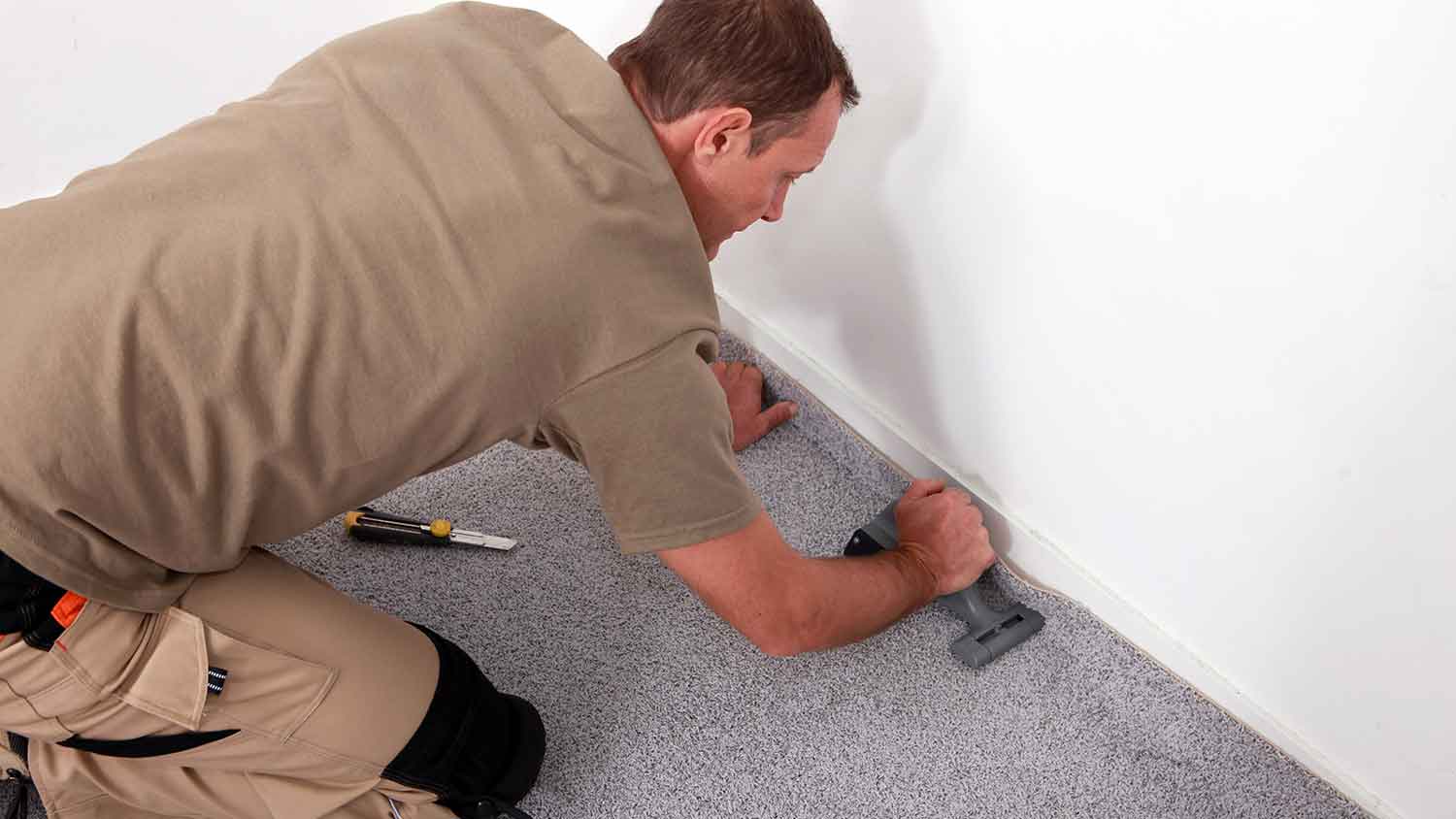 None Worker installing carpet in the room