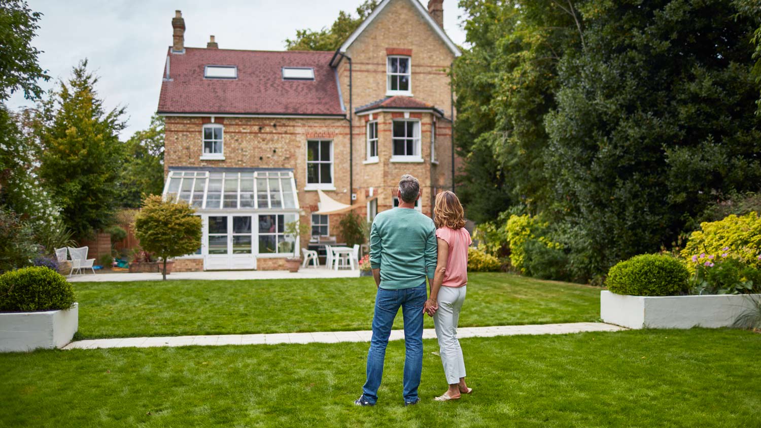 None Couple on a garden looking at a house