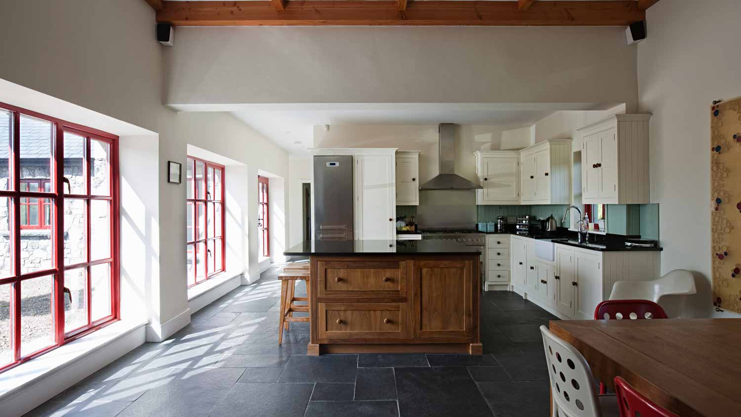 A spacious kitchen with dark tiles on the floor