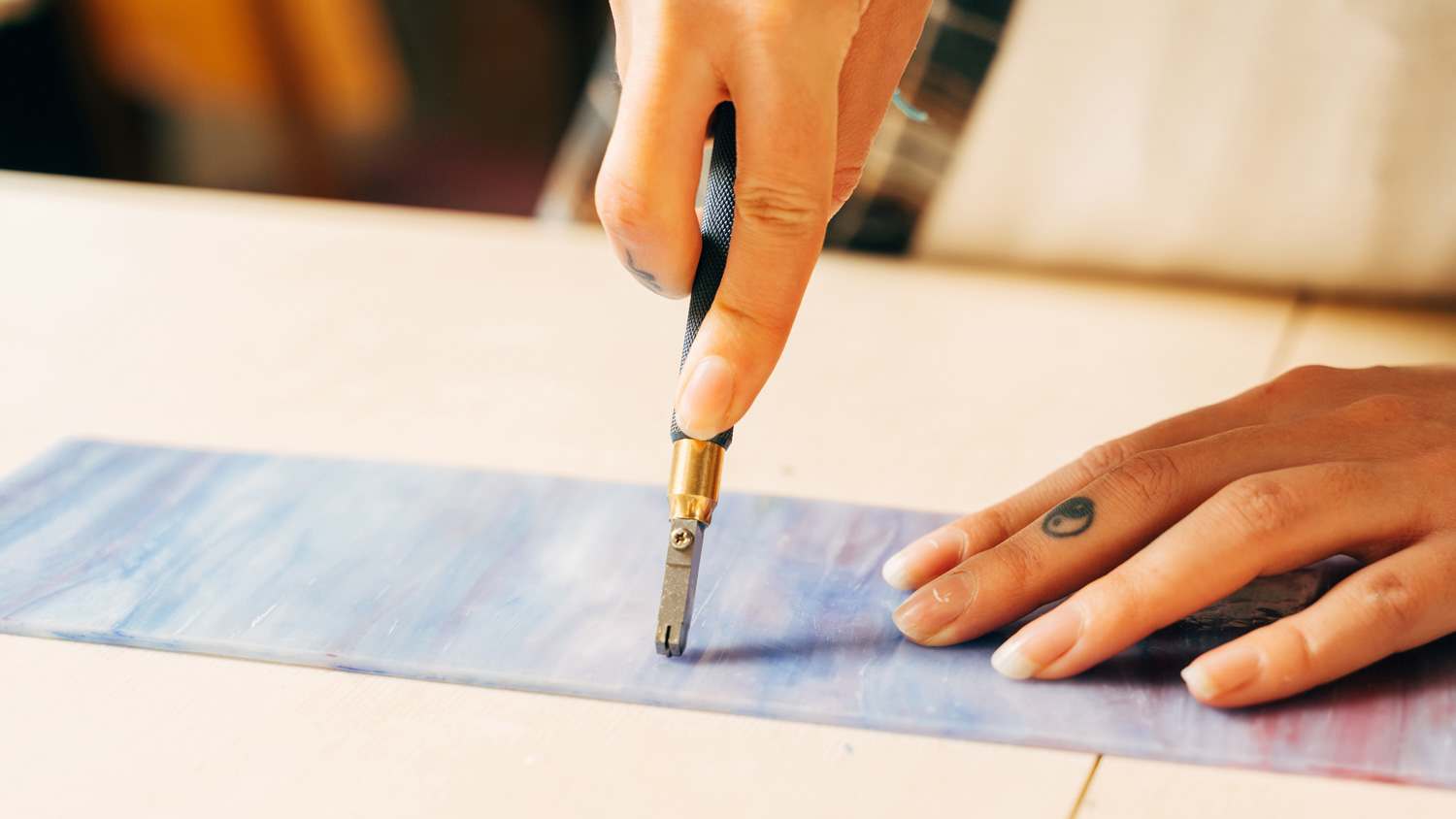 None Woman scoring piece of glass