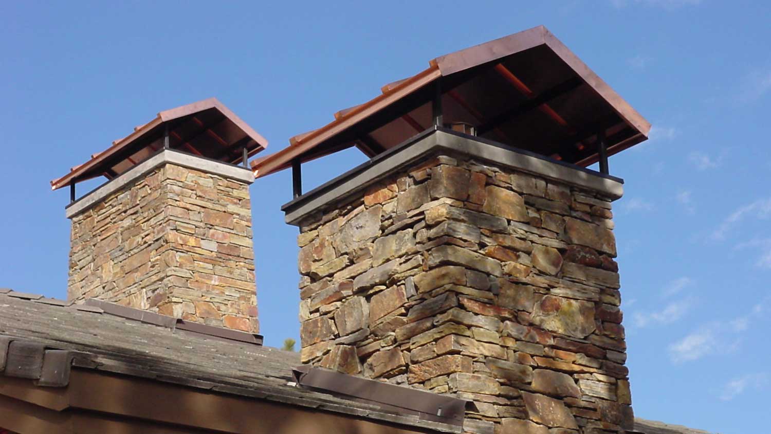 None Two stone chimneys with chimney caps