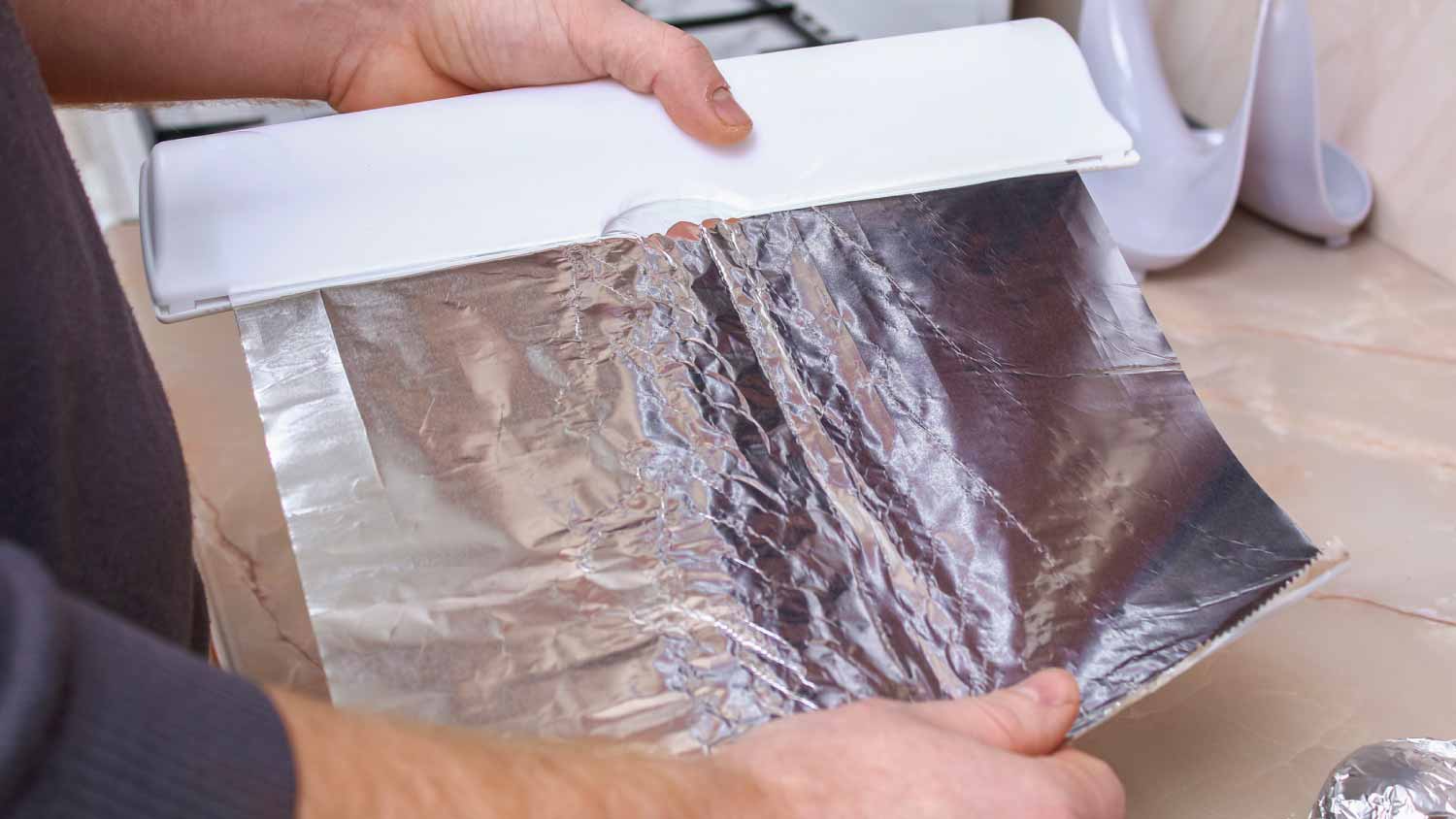 A man tears off the foil from plastic dispenser