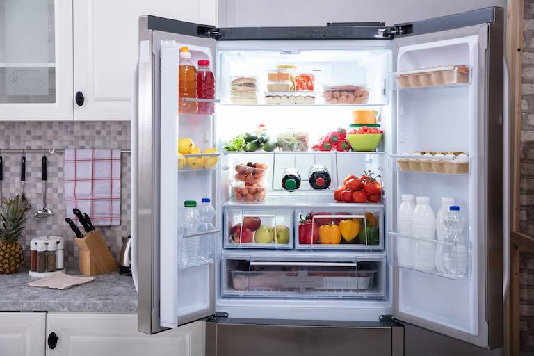 view of open refrigerator with organized food in shelves in a home kitchen
