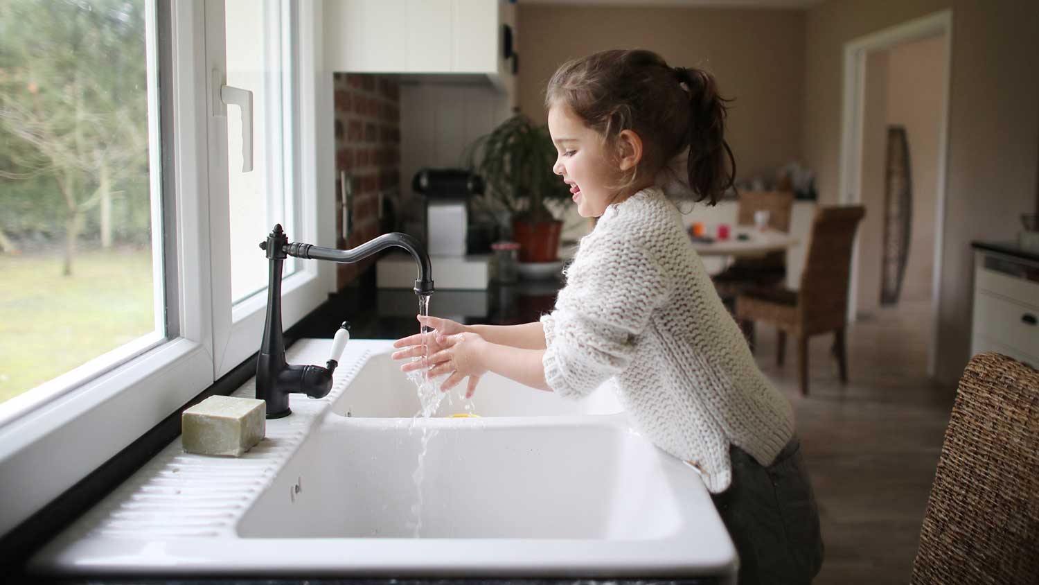 Woman with rolled up sleeves is washing her hands