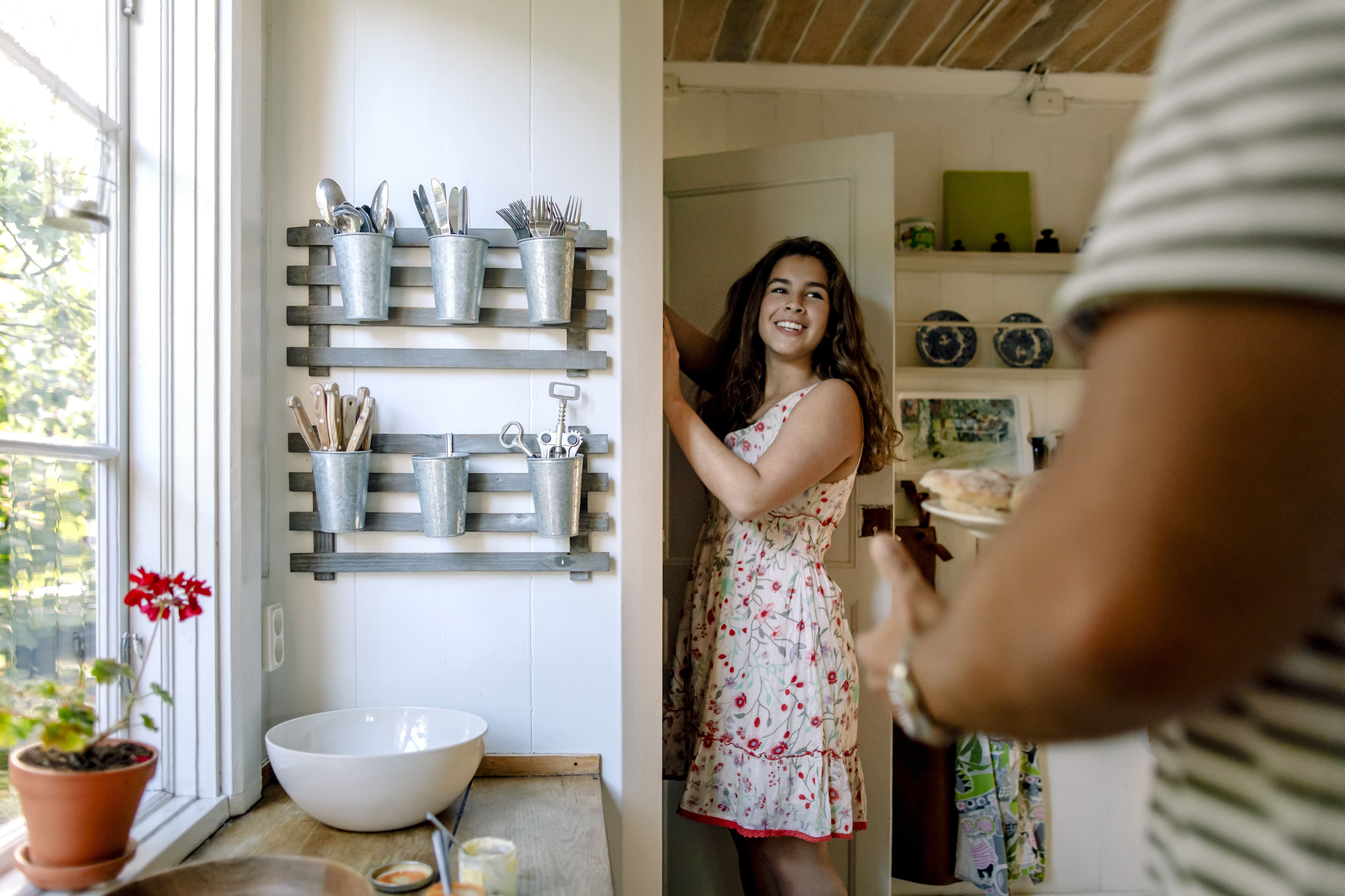 Woman in kitchen opening pantry door