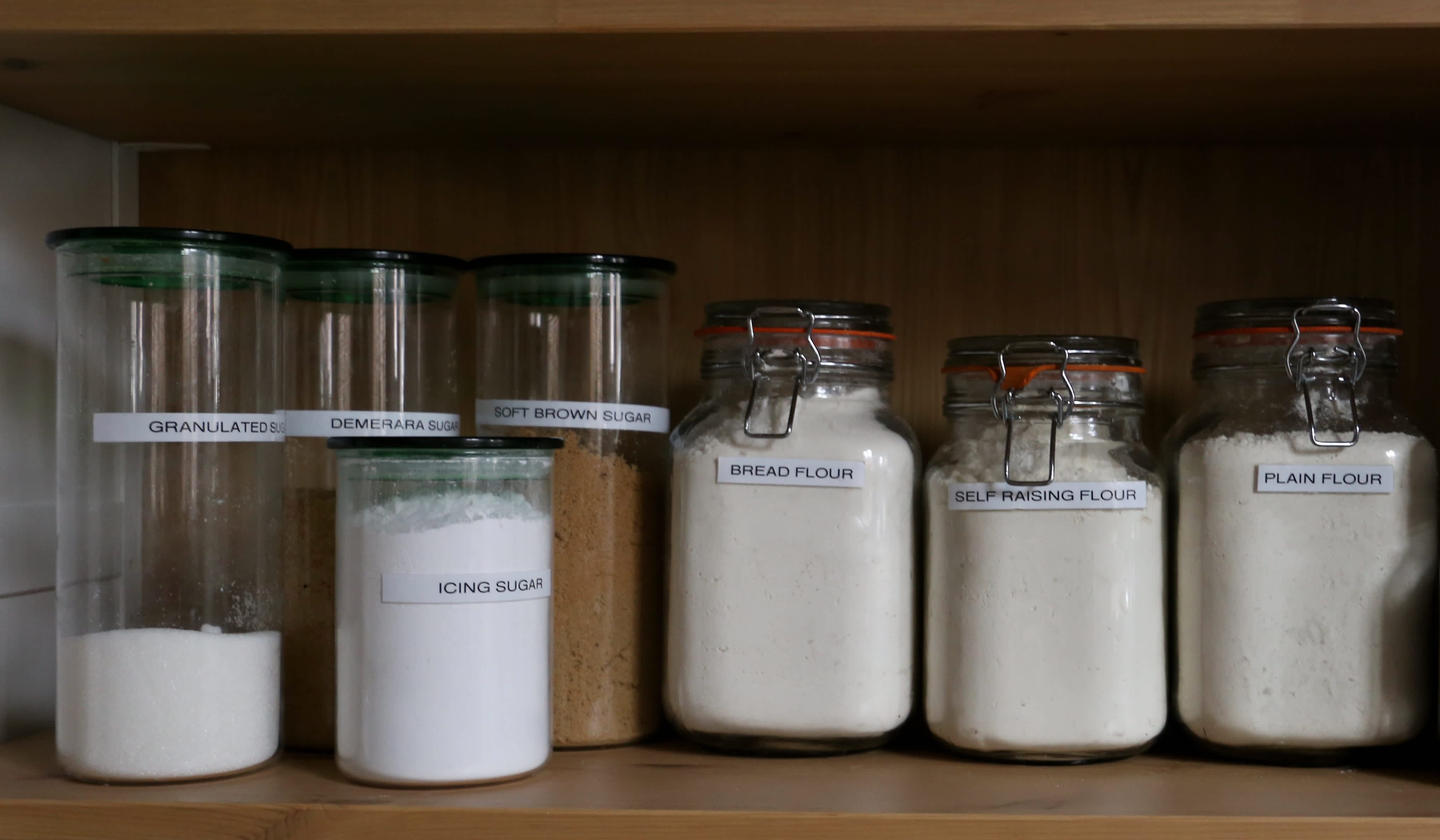 Dry goods labeled in jars in kitchen pantry