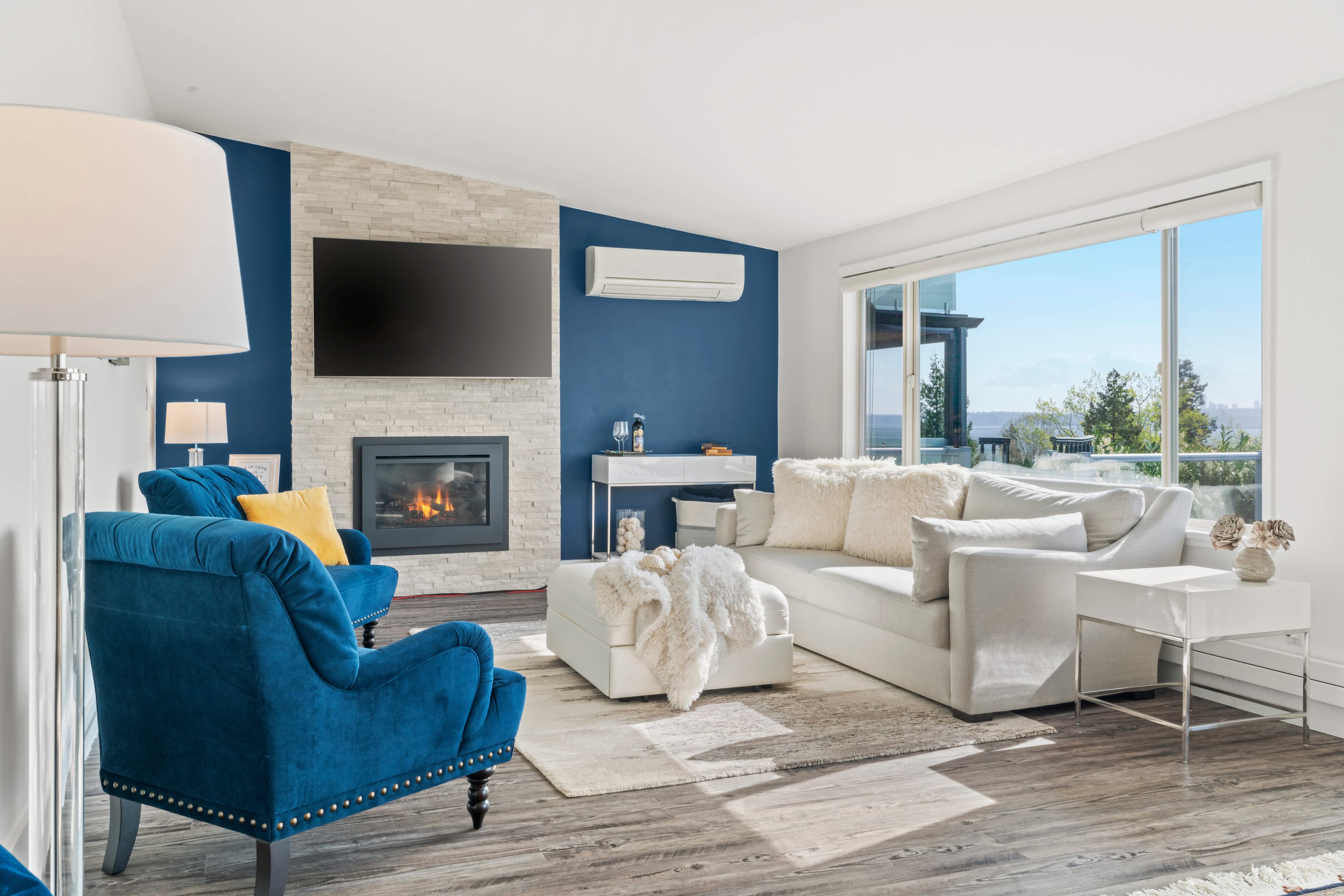 A modern white living room with a blue accent wall and chairs