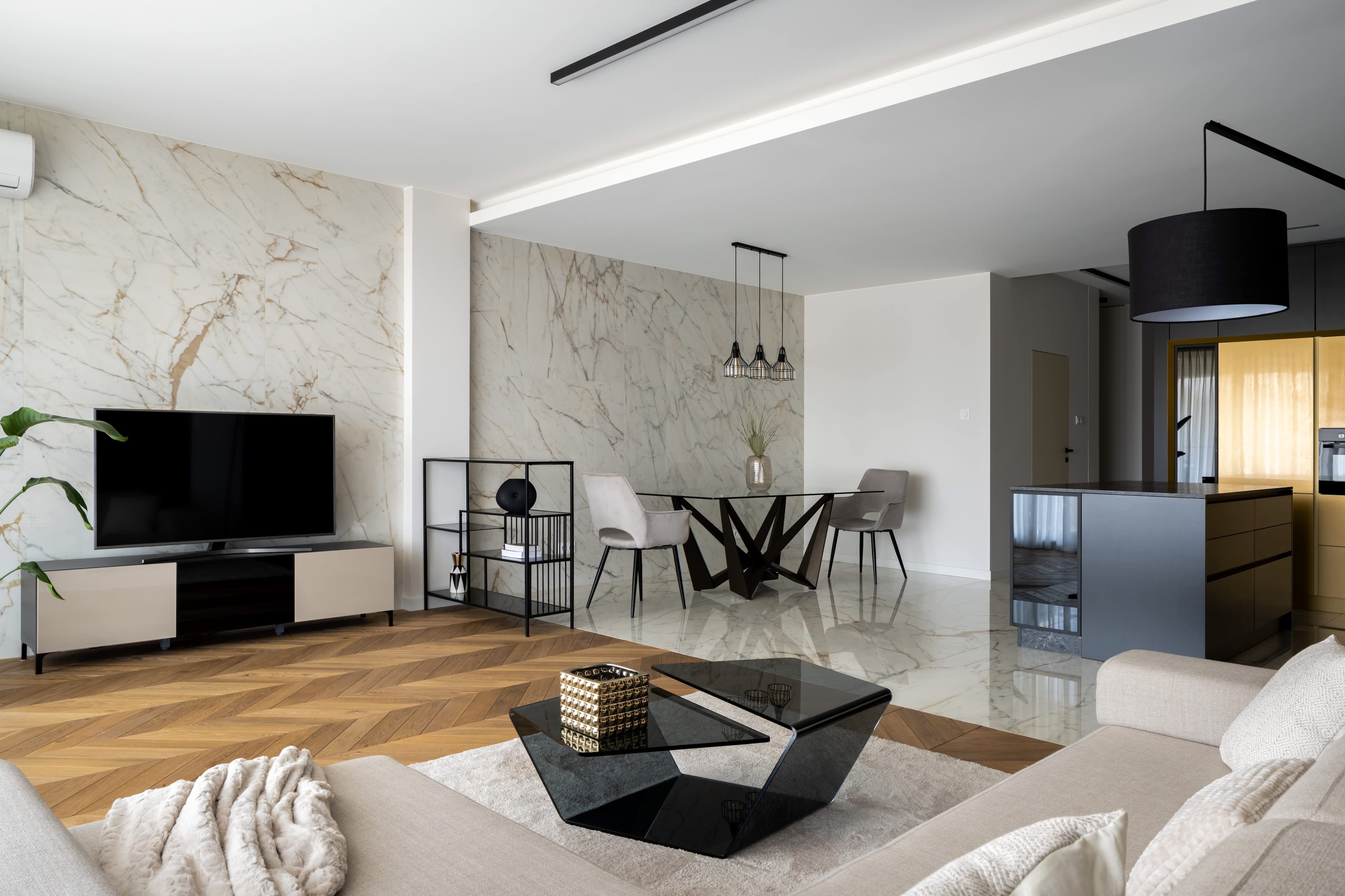 A modern living space with a marble accent wall and Art Deco accents