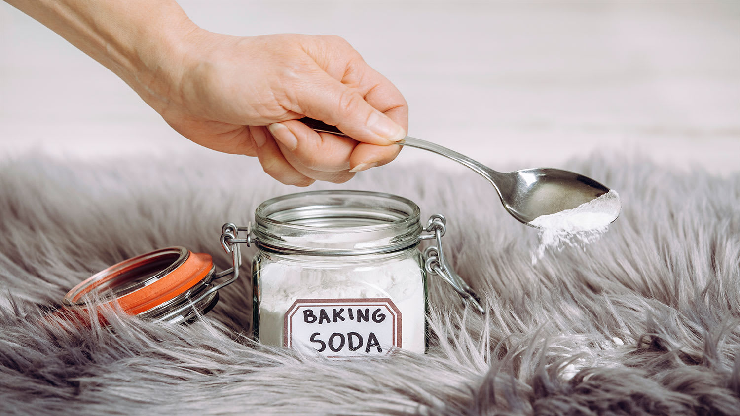 None Someone sprinkling baking soda on carpet stain