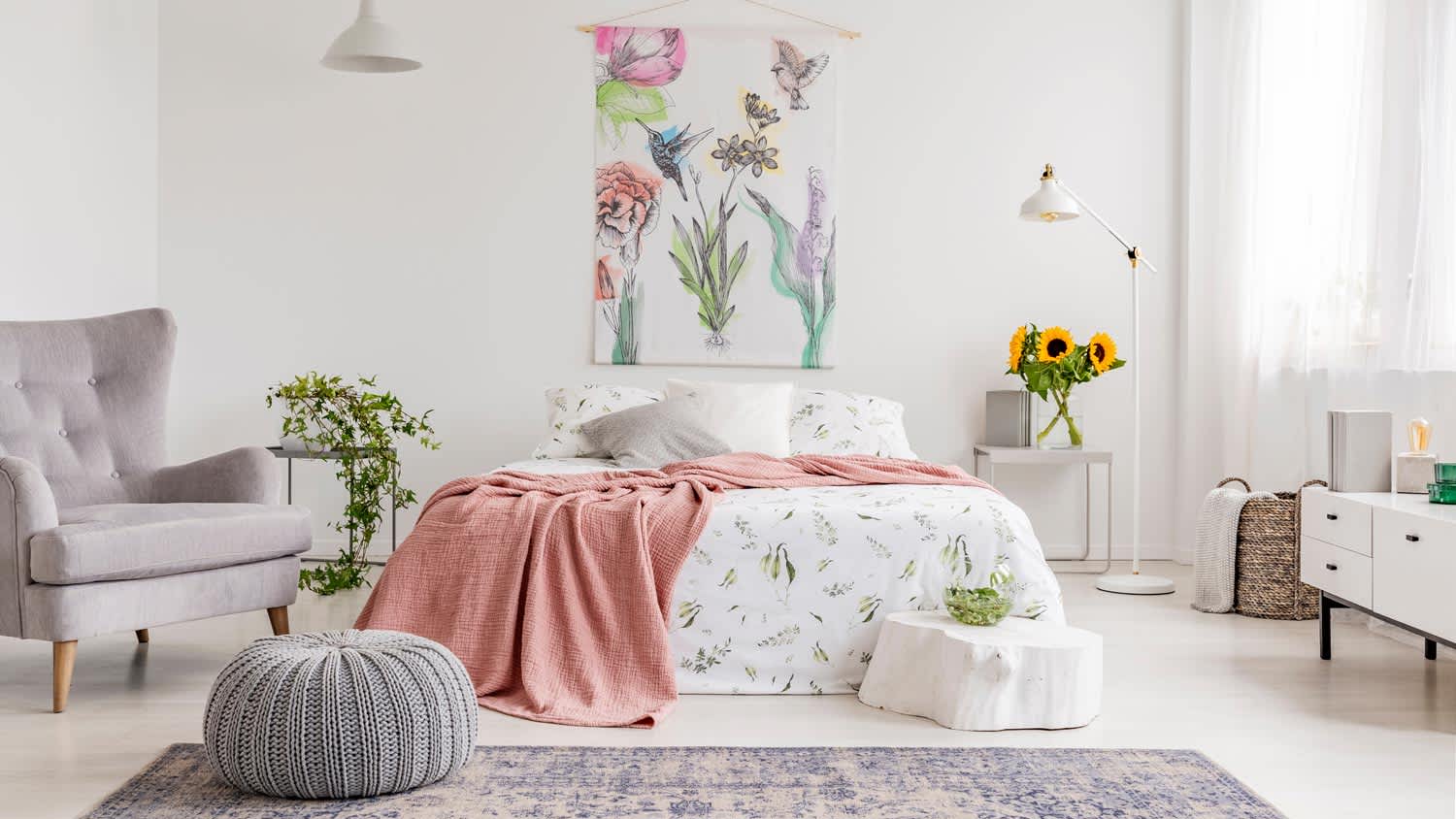 A bright bedroom with a tapestry hanged above the bed