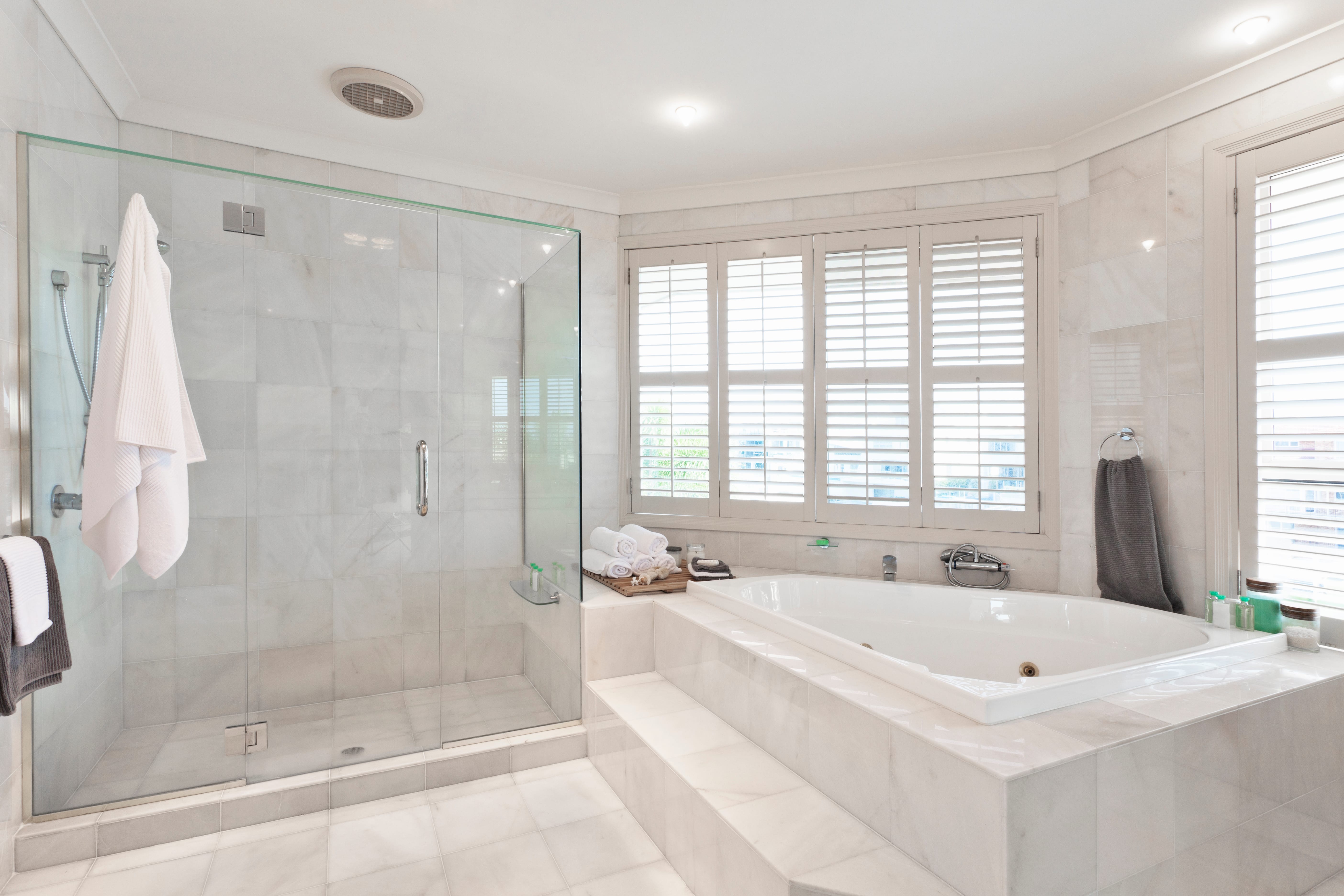 All-white modern bathroom with floor-to-ceiling tiling