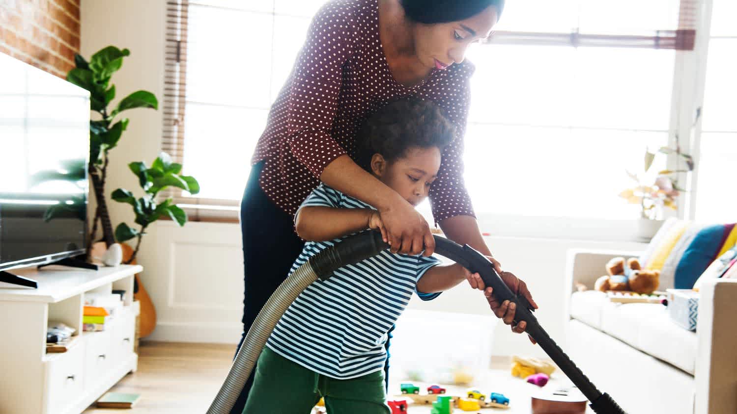 A mom and her son vacuuming the living room
