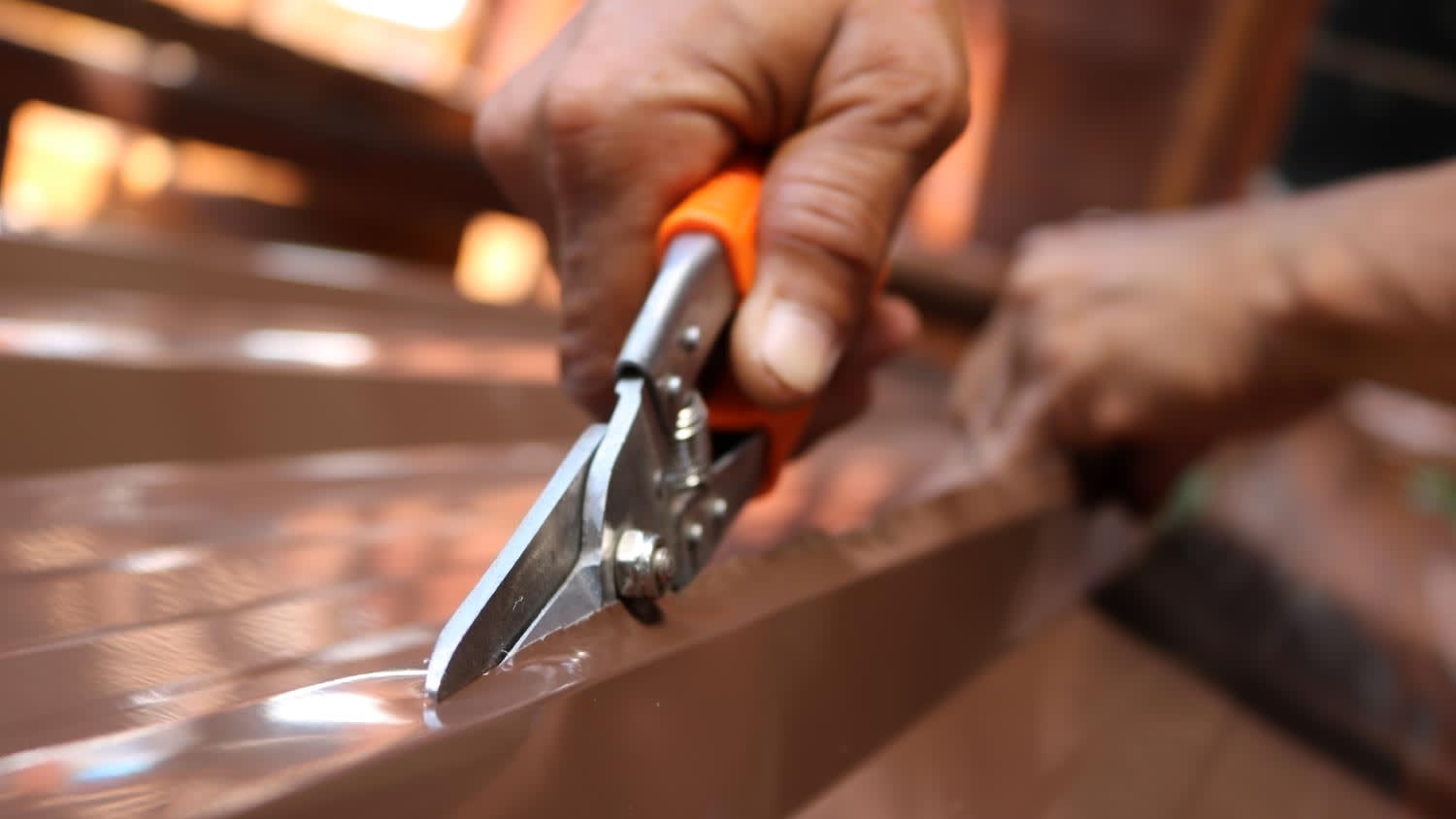 None Worker using scissors to cut the metal sheet for roofing
