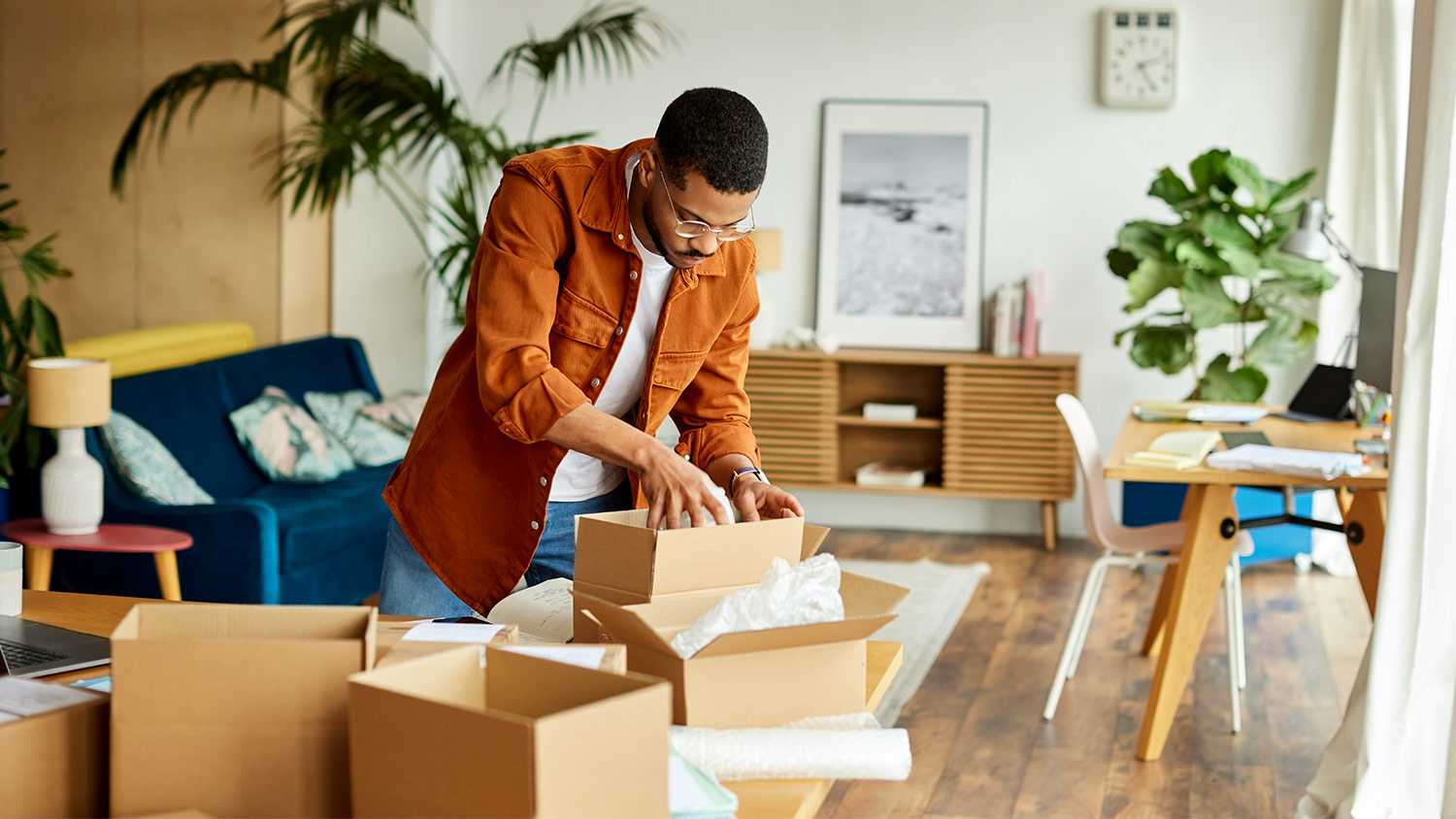 Man packing boxes in living room