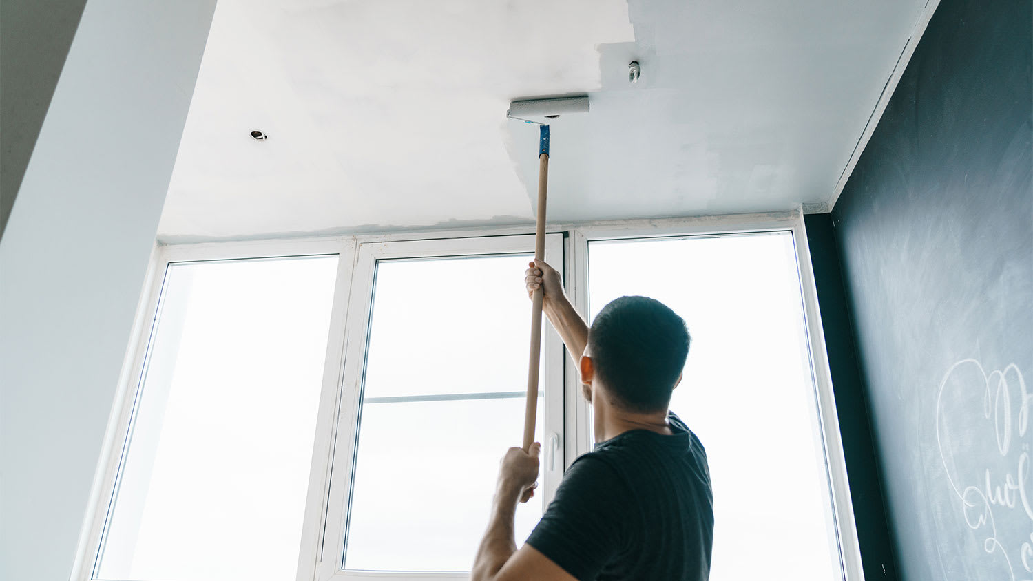 A man paints a ceiling