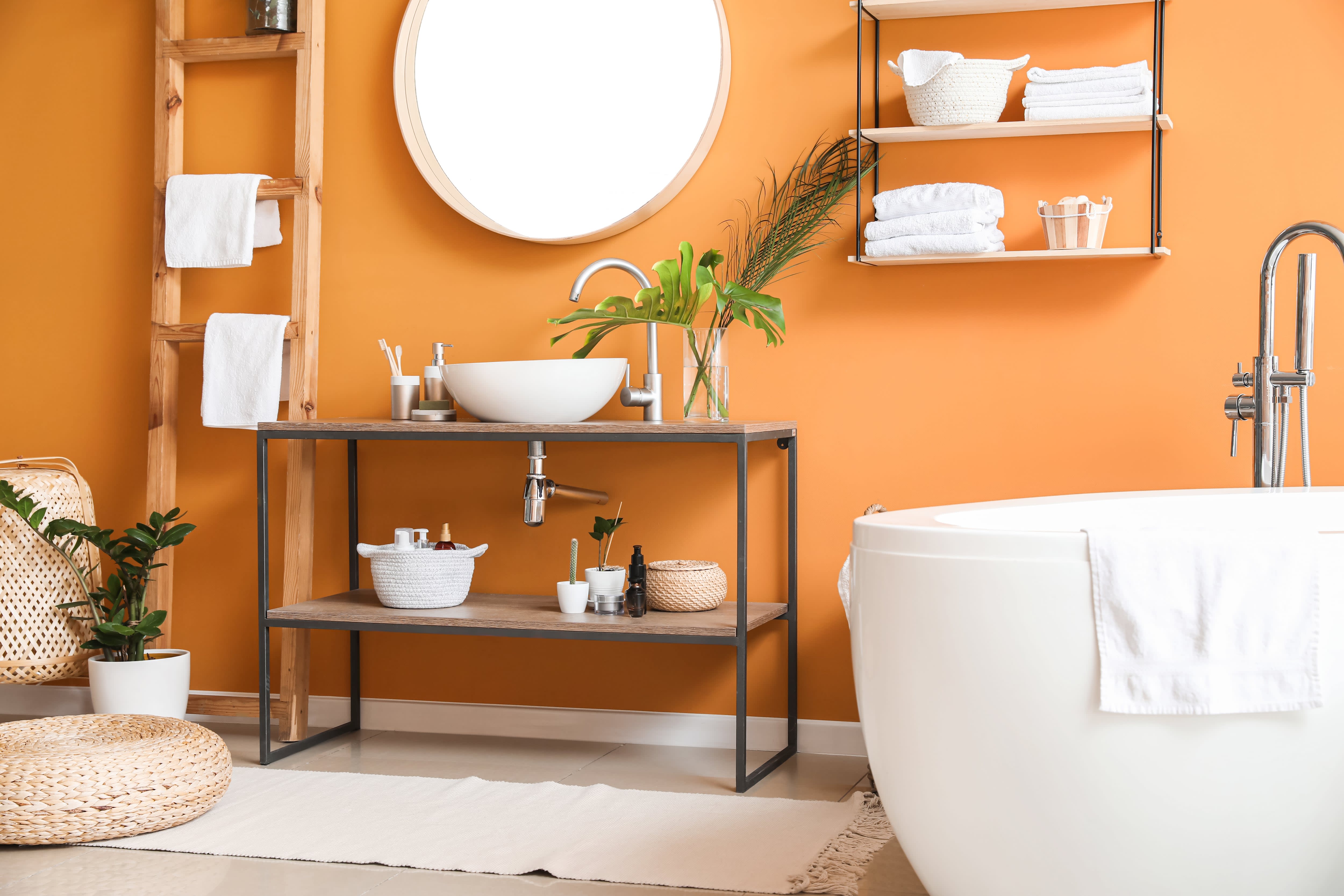 Modern bathroom with warm, orange paint color and wood accents