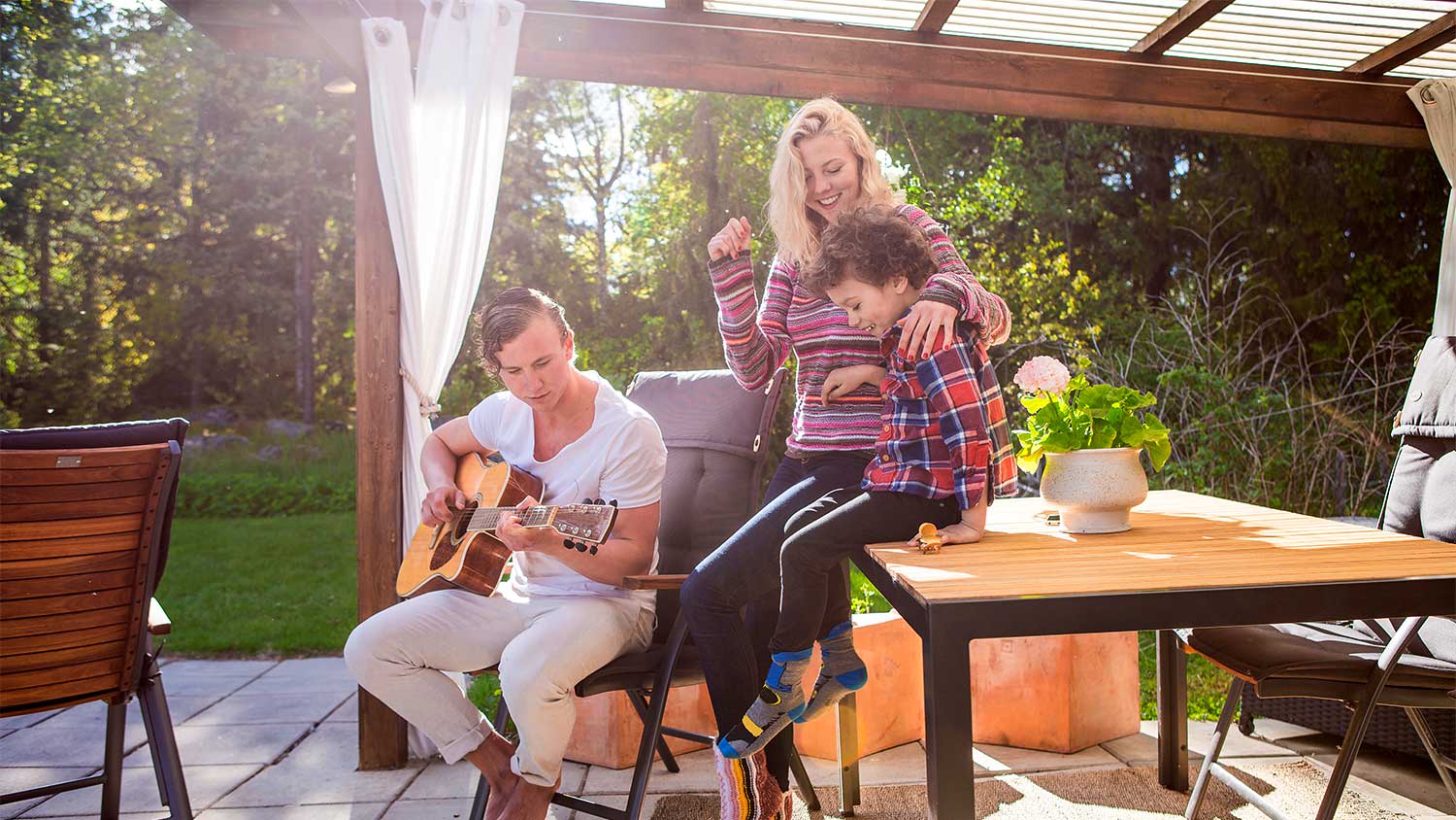 A family plays under a pergola