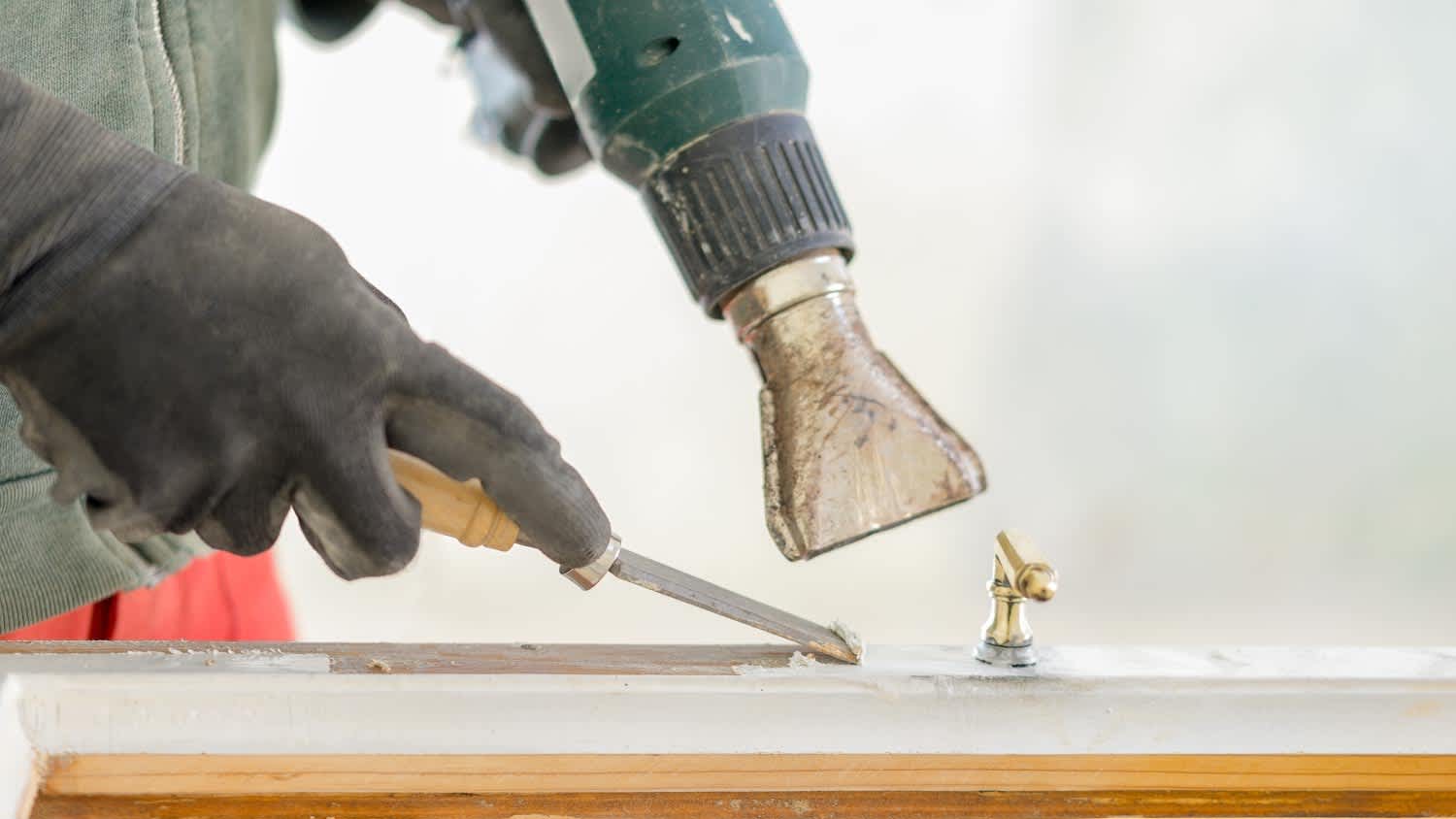 None A man restoring a window frame