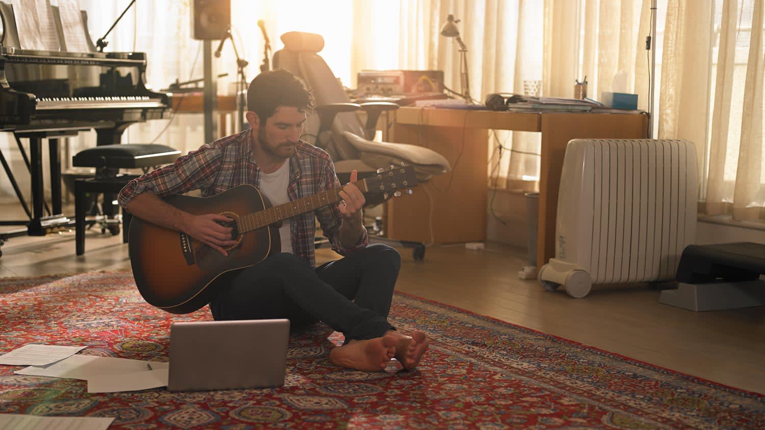 A man playing the guitar in his music room