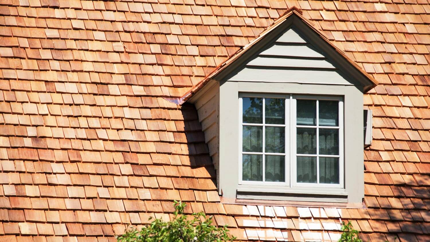 A dormer house with a cedar shake roof