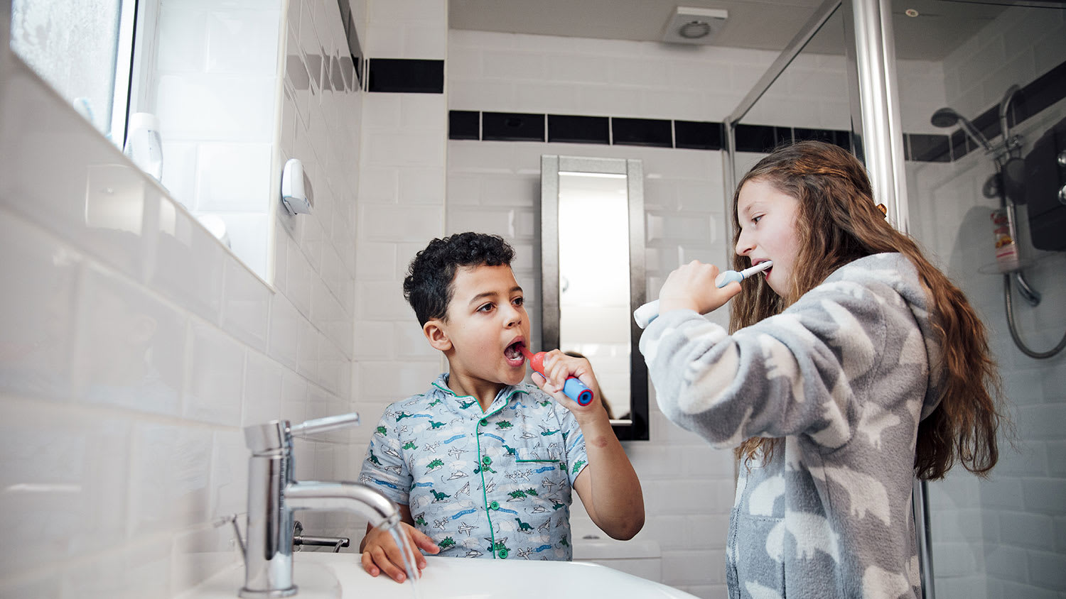 Brother and sister brushing teeth in the bathroom
