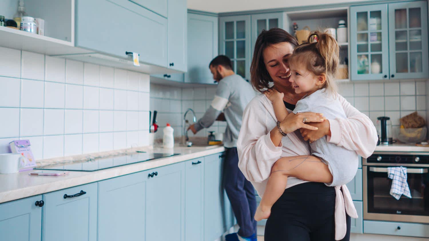 Dad, mom and little daughter in the kitchen