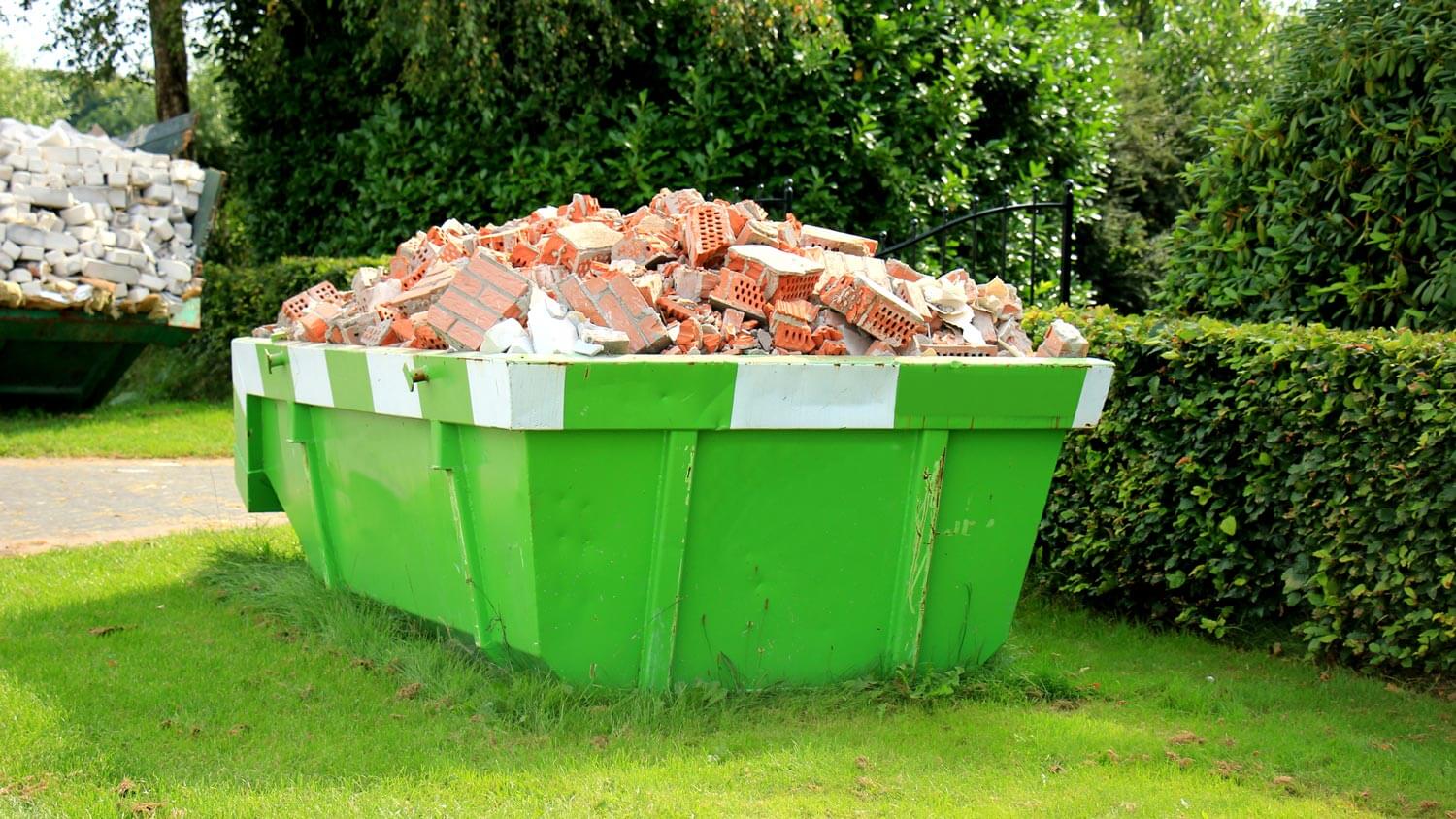 An loaded green dumpster with materials from a construction site