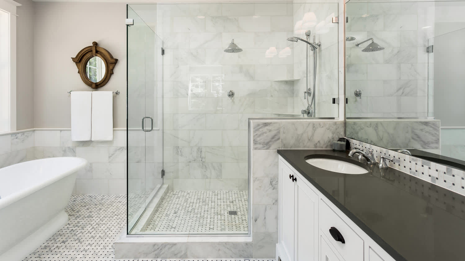 A master bathroom with a glass shower and a white bathtub
