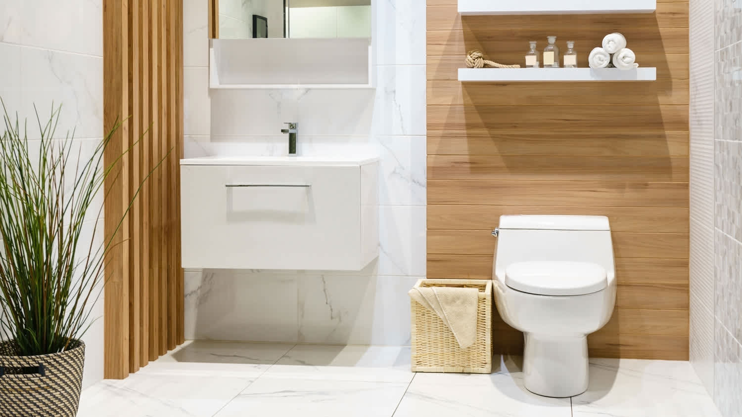 A standard height toilet in a bathroom with marble tiles