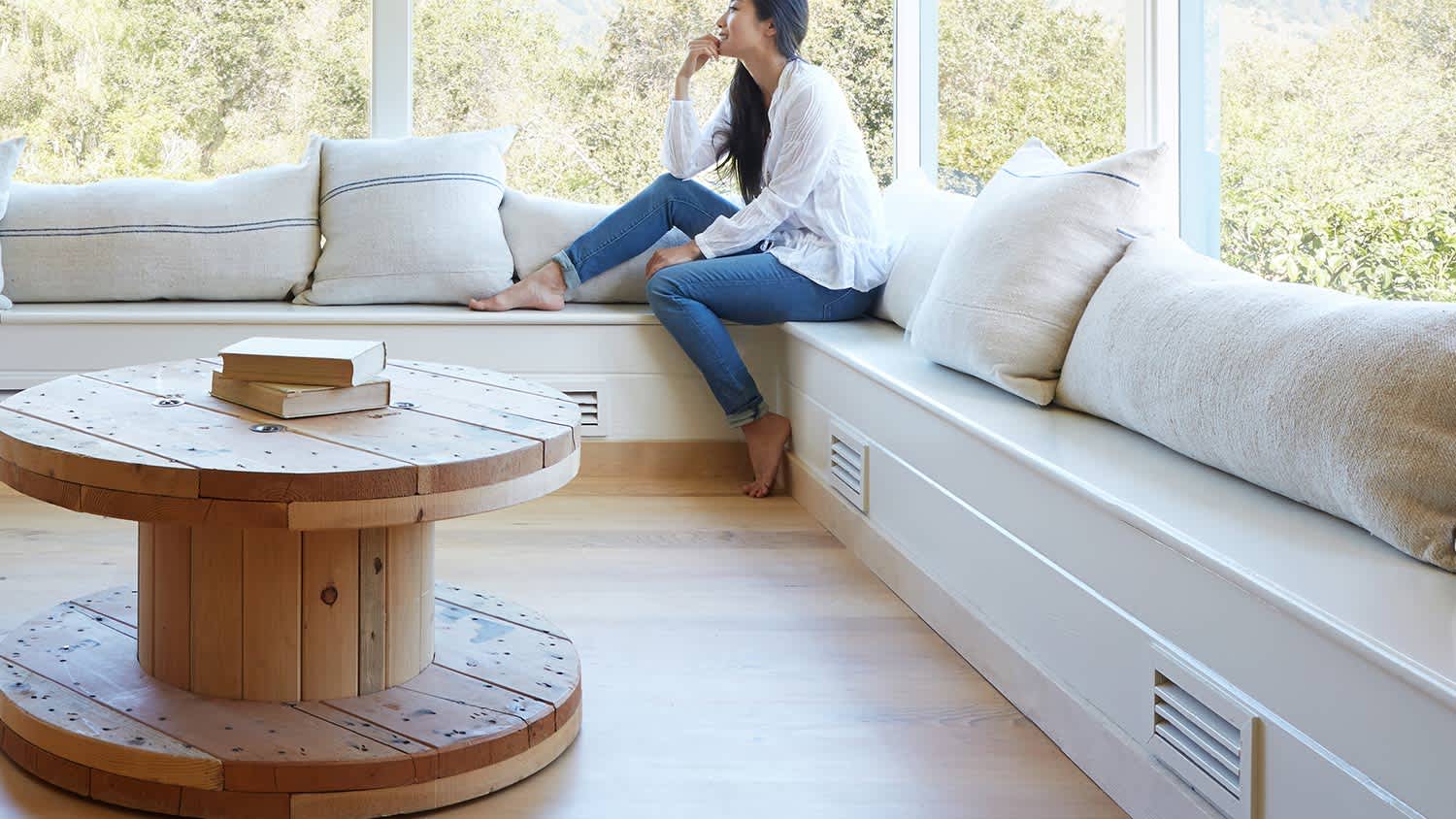 Woman sitting by window vent pillows