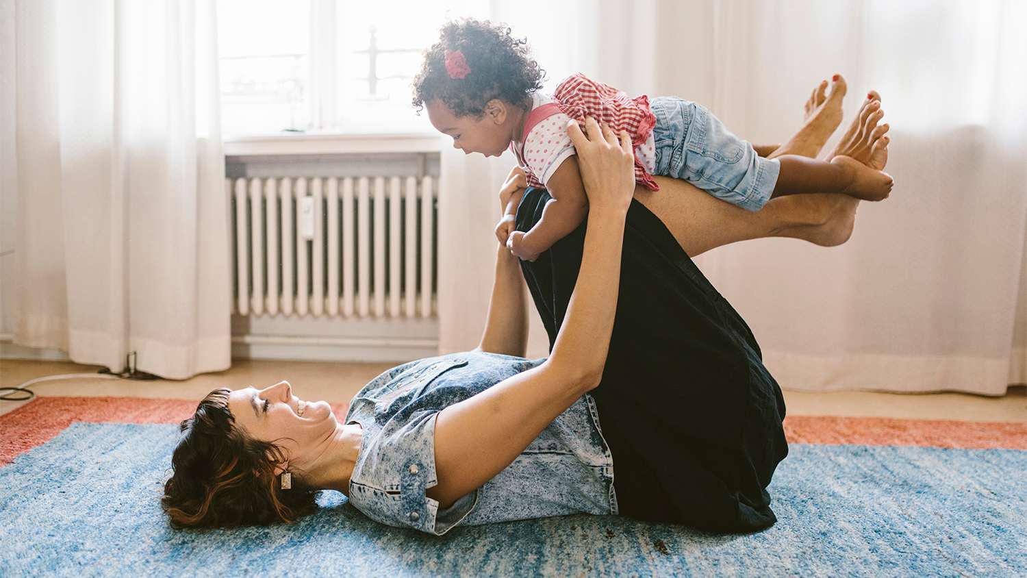 mother and daughter playing in living room