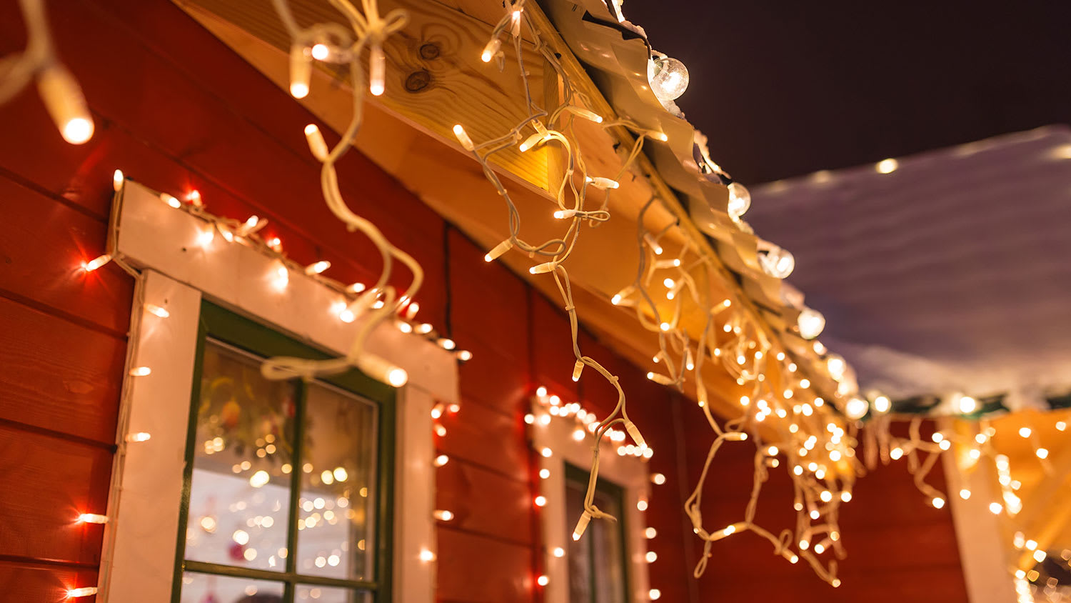 Christmas lights hanging from a house roof