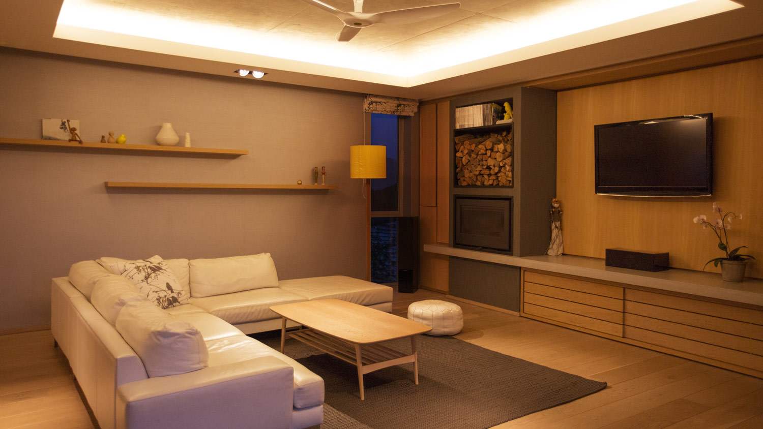 A living room with hidden lighting in a vaulted ceiling