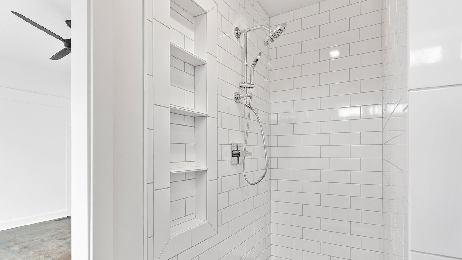 White tiled shower with four niches