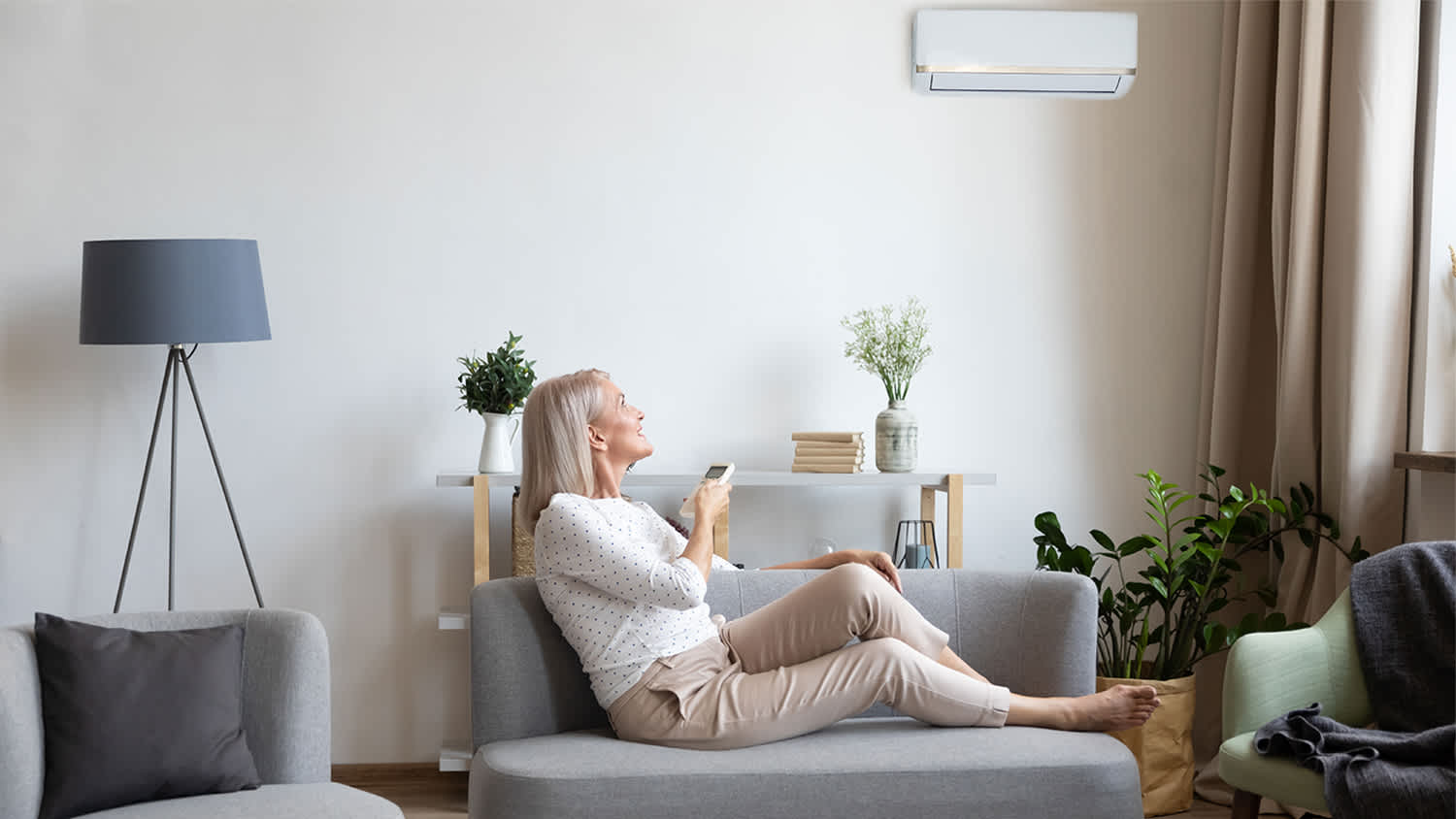 woman relaxing on couch adjusting ac
