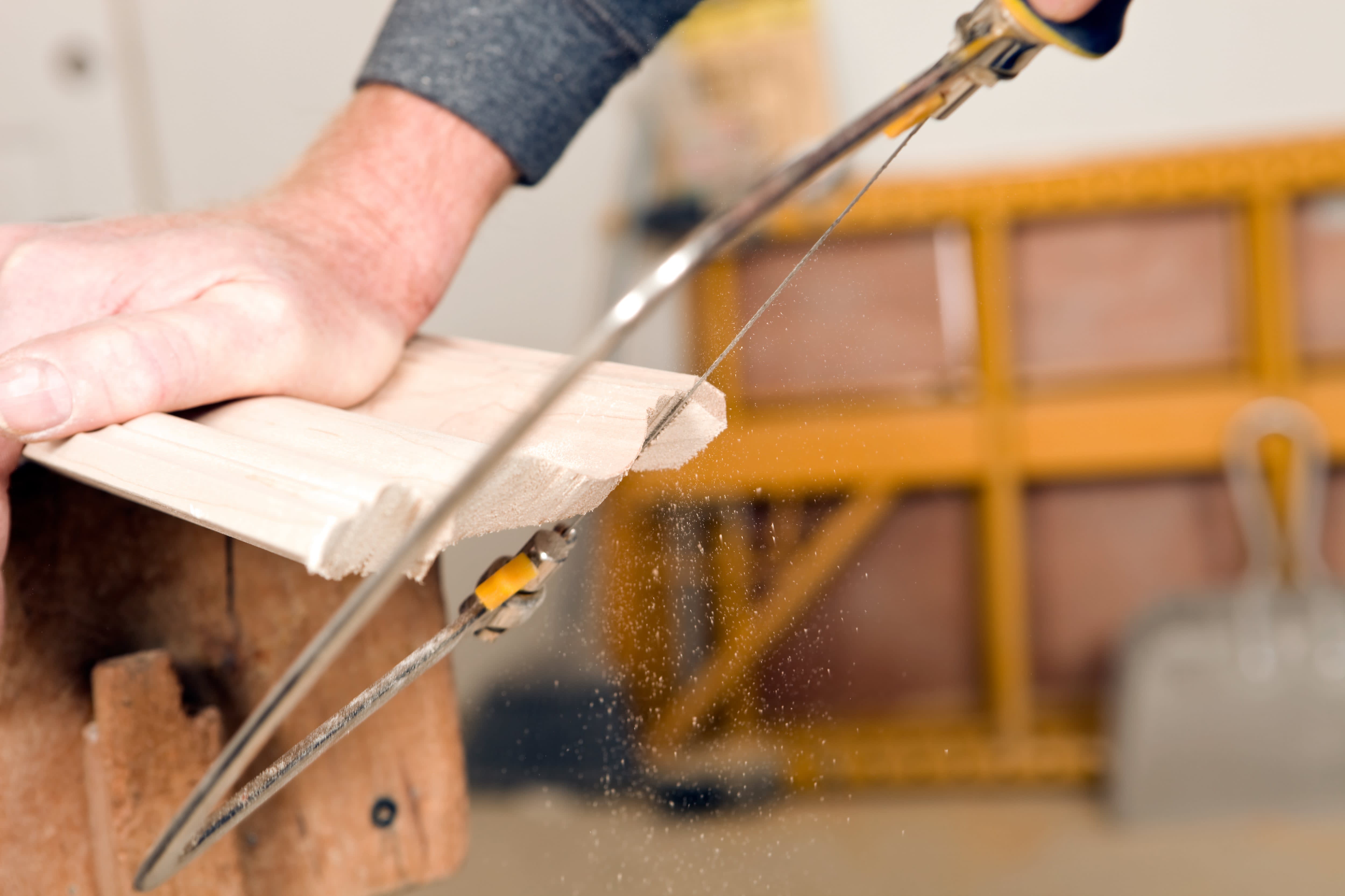 Carpenter using a coping saw on millwork trim