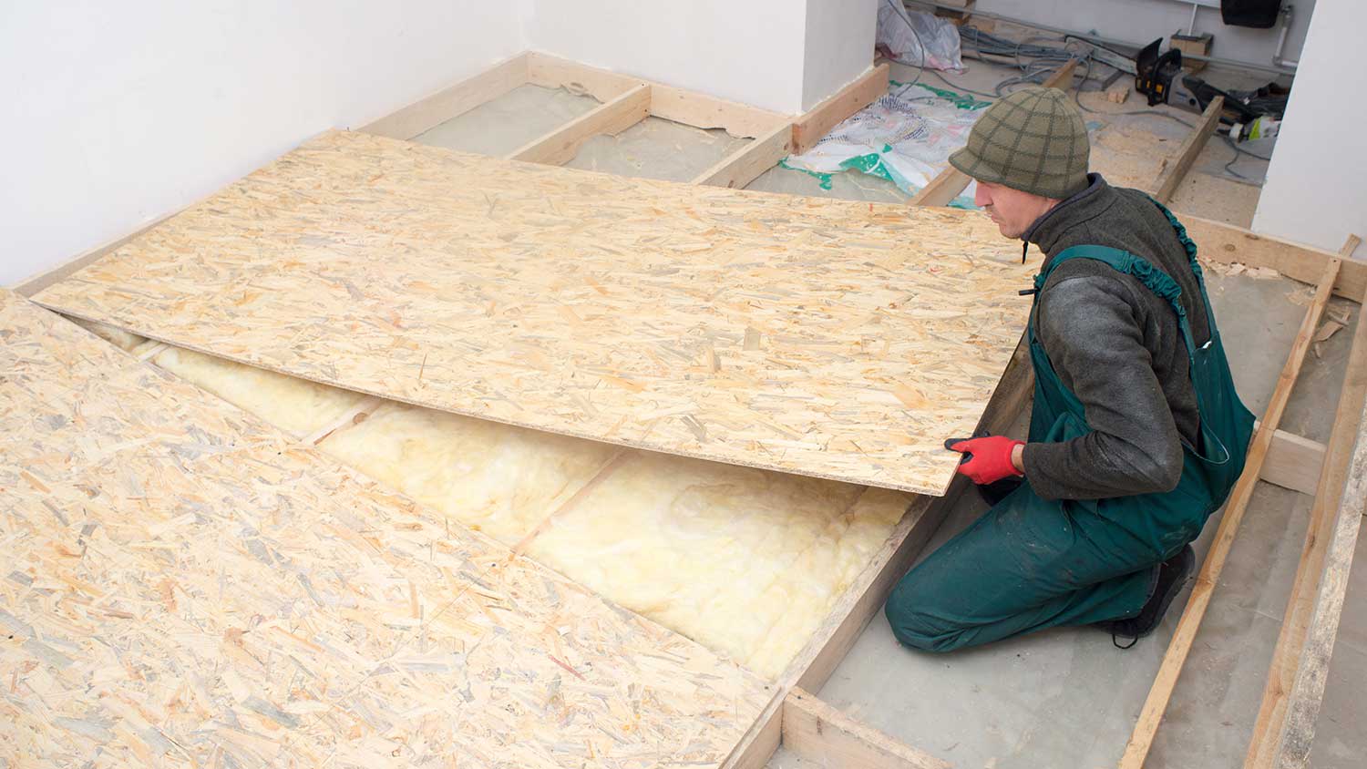 Handyman using osb boards to build insulated floor