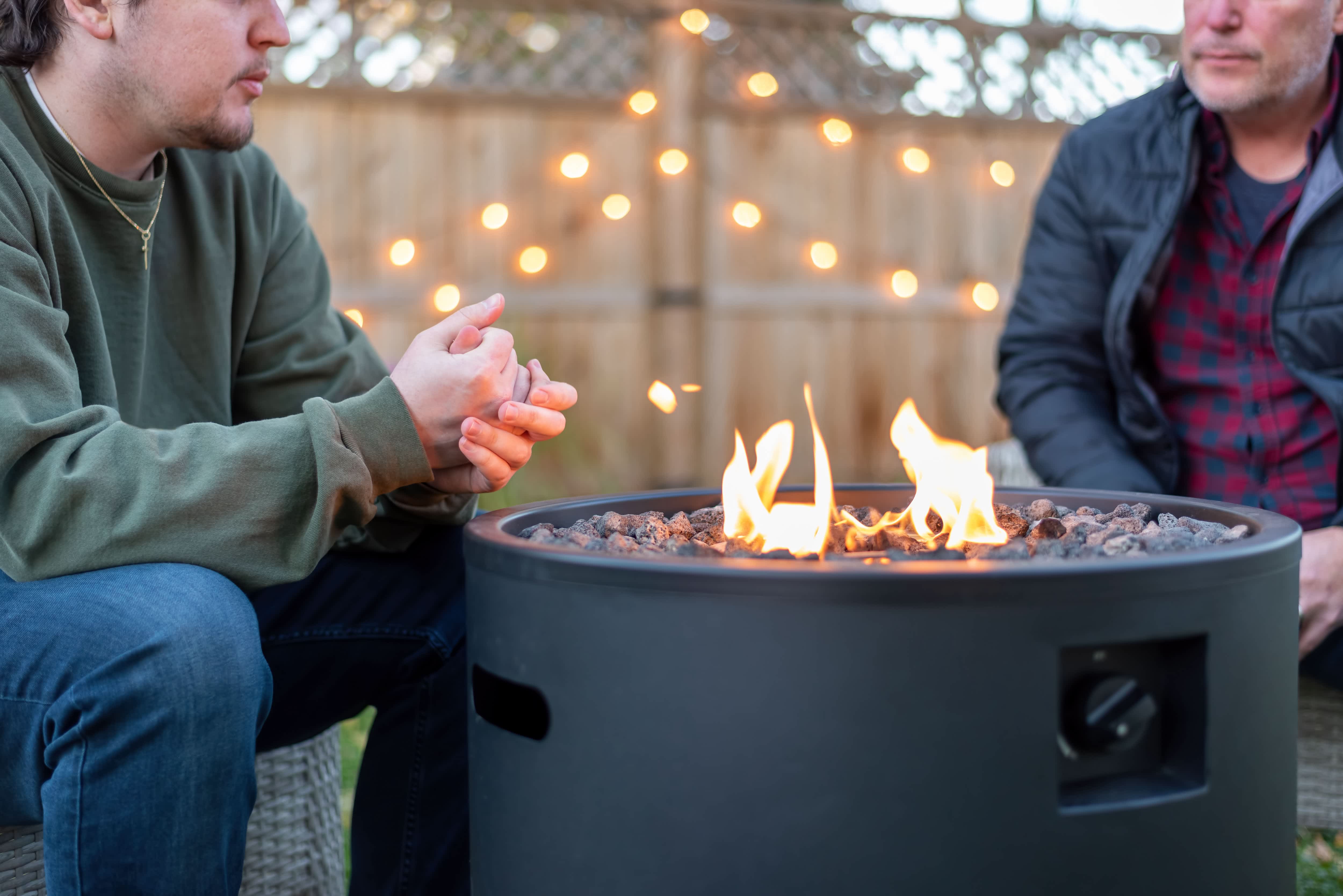 Two people talking around a propane fire pit